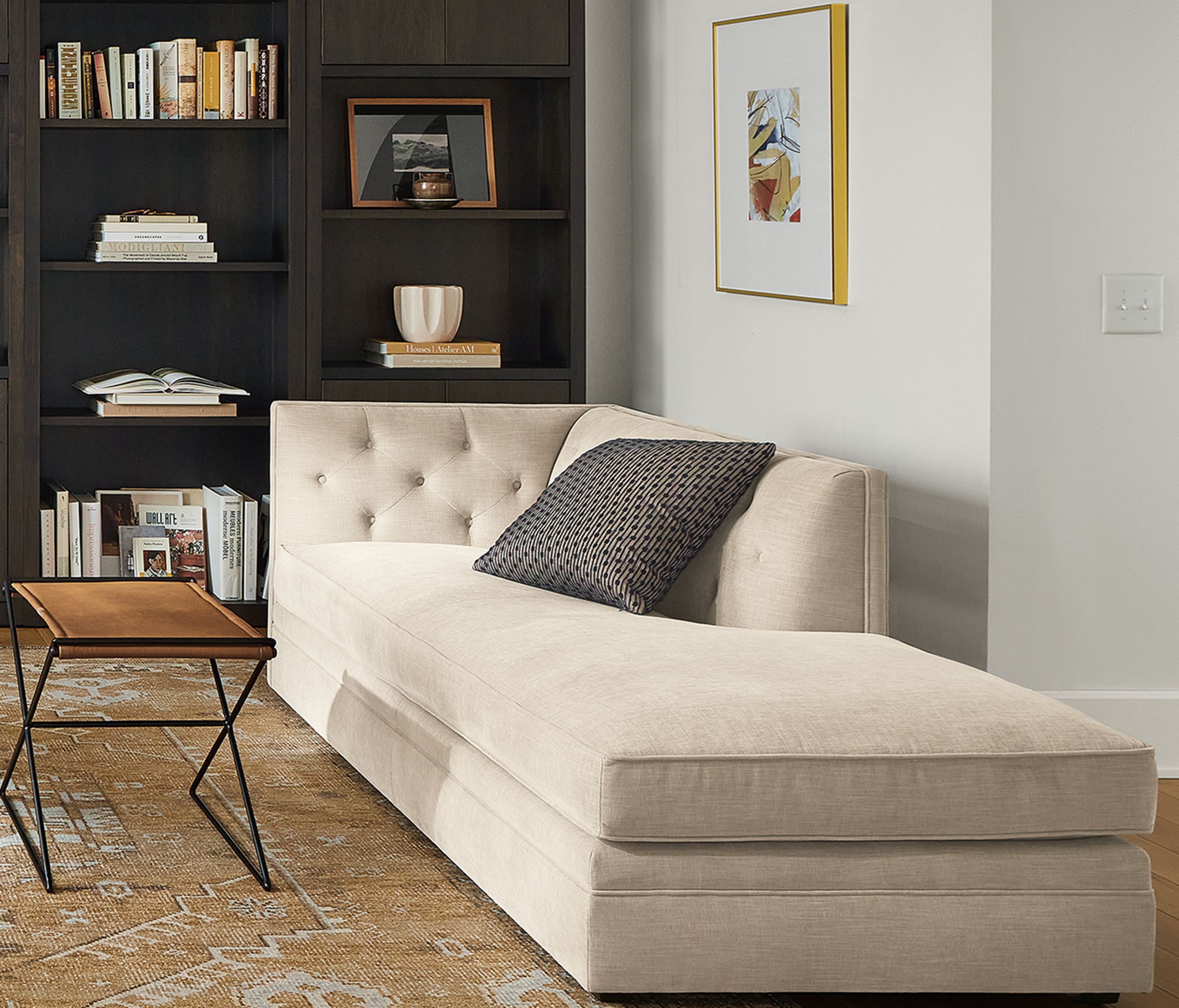 Living room with Macalester sofa and Macalester chaise, Charcoal woodwind bookcases in charcoal, and Darrah rug.