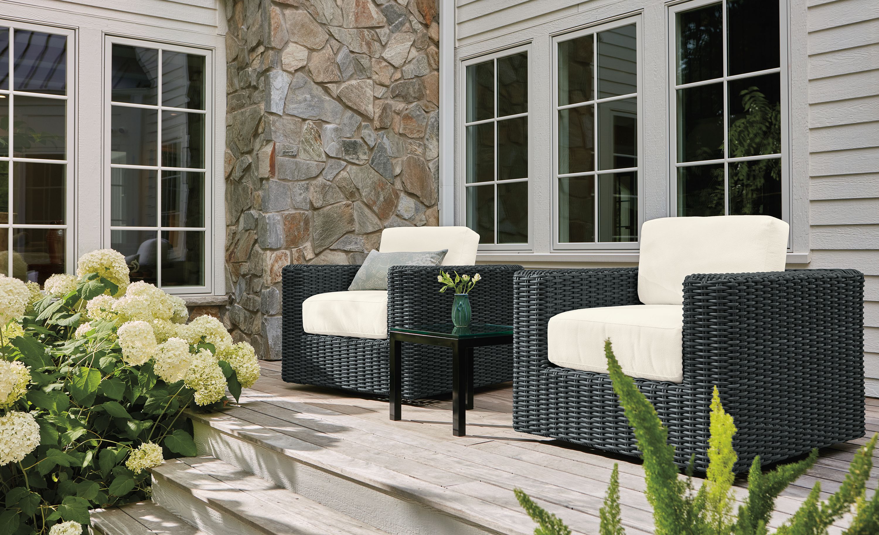 Home deck with 2 Madura swivel chairs in Dusk Ivory and charcoal weave and Parsons coffee table in graphite and clear glass.