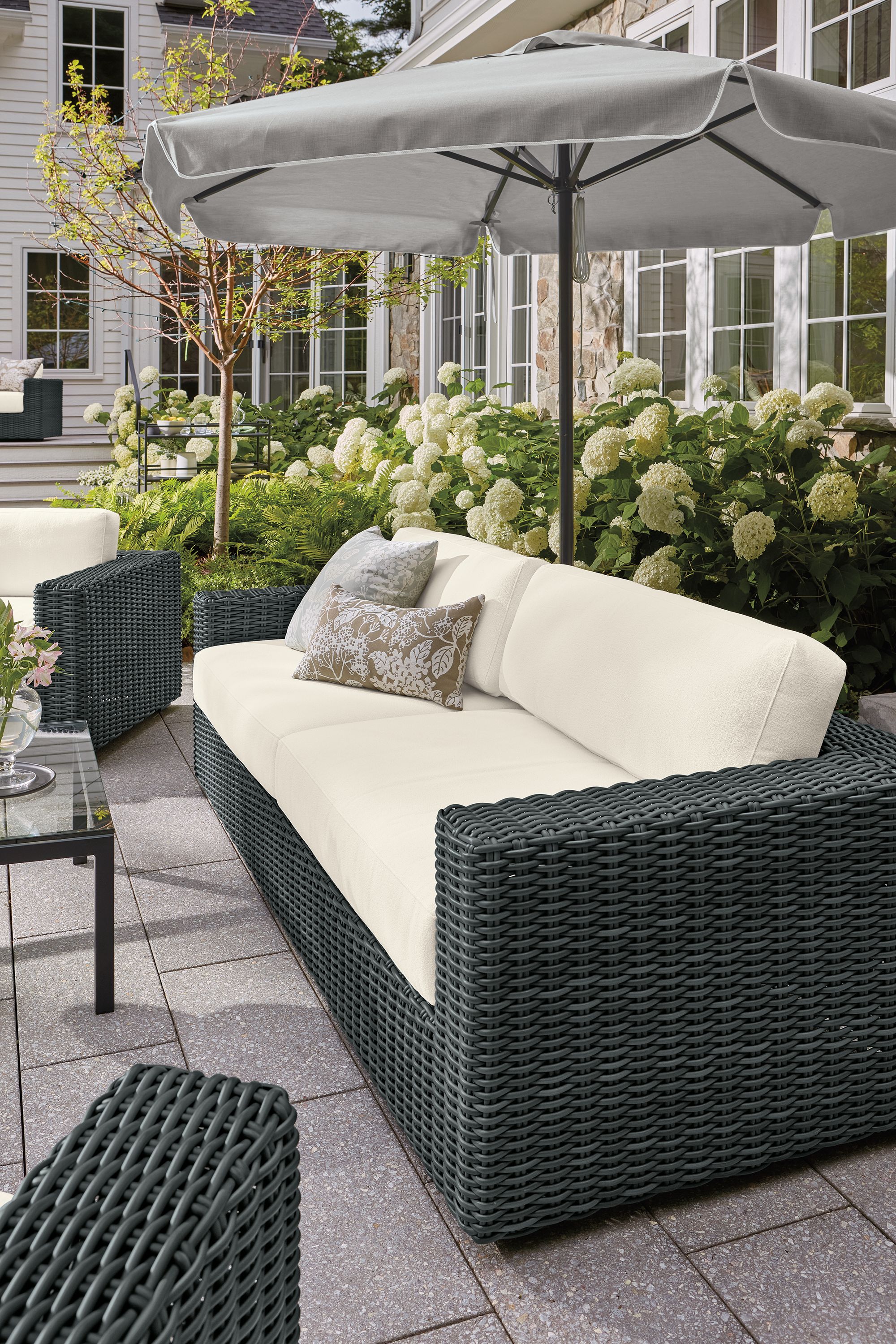 Patio with Madura sofa, lounge chair and swivel chair in dusk ivory and charcoal weave and parsons coffee table.