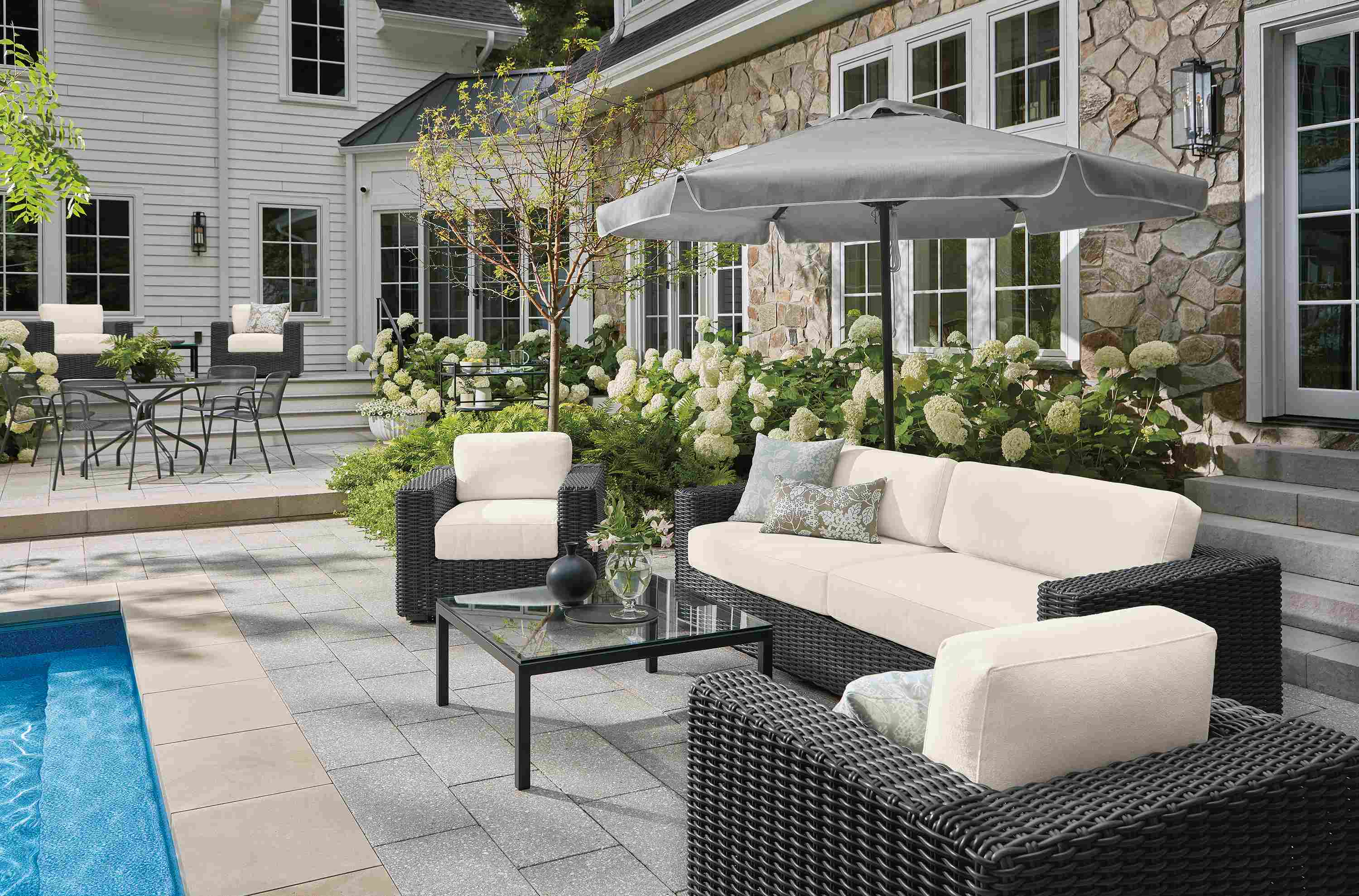 Poolside area with Madura sofa, lounge chair and swivel chair in Dusk Ivory and charcoal weave.