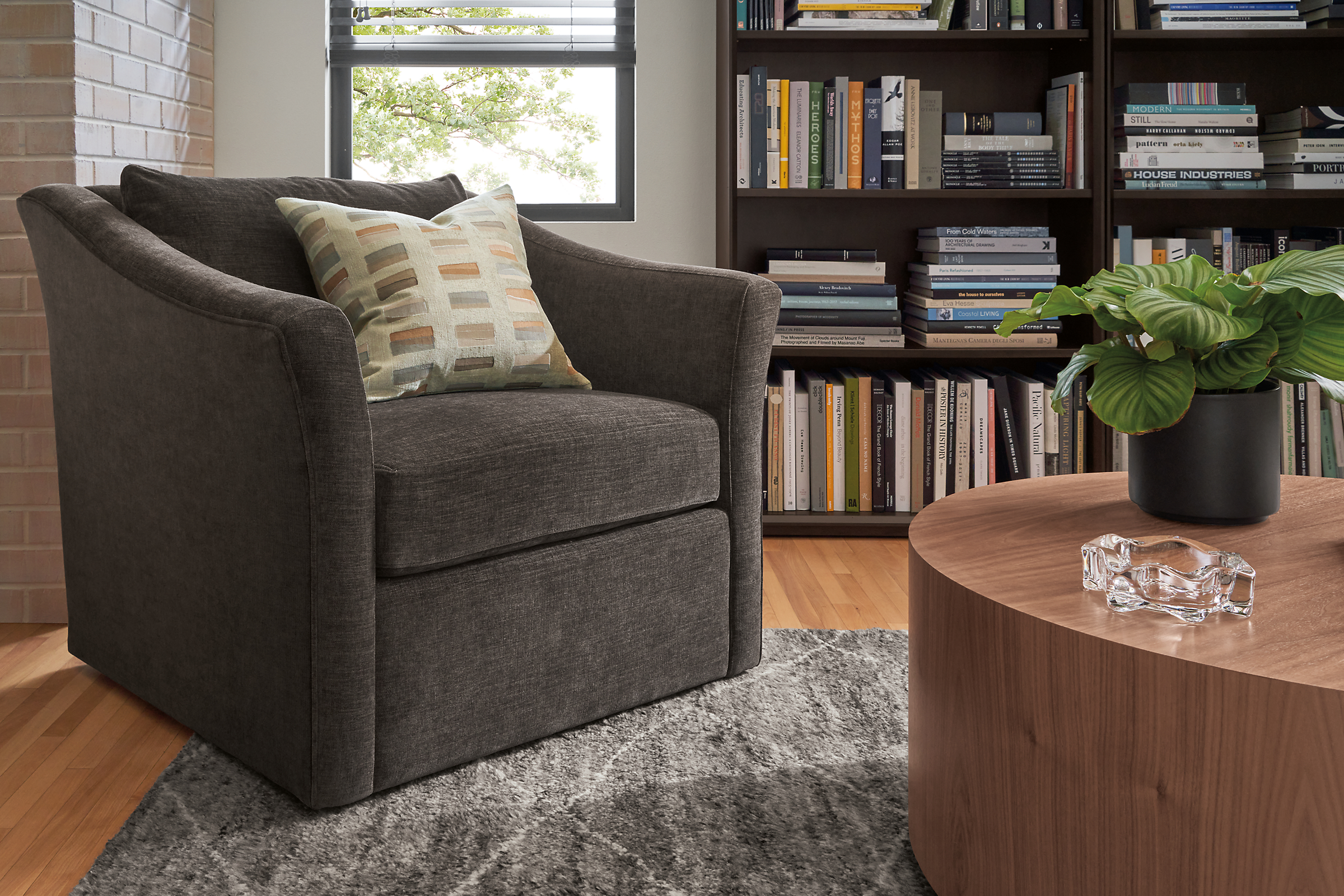 living room withe maeve swivel chair in mori charcoal, liam coffee table and rollins bookcases.