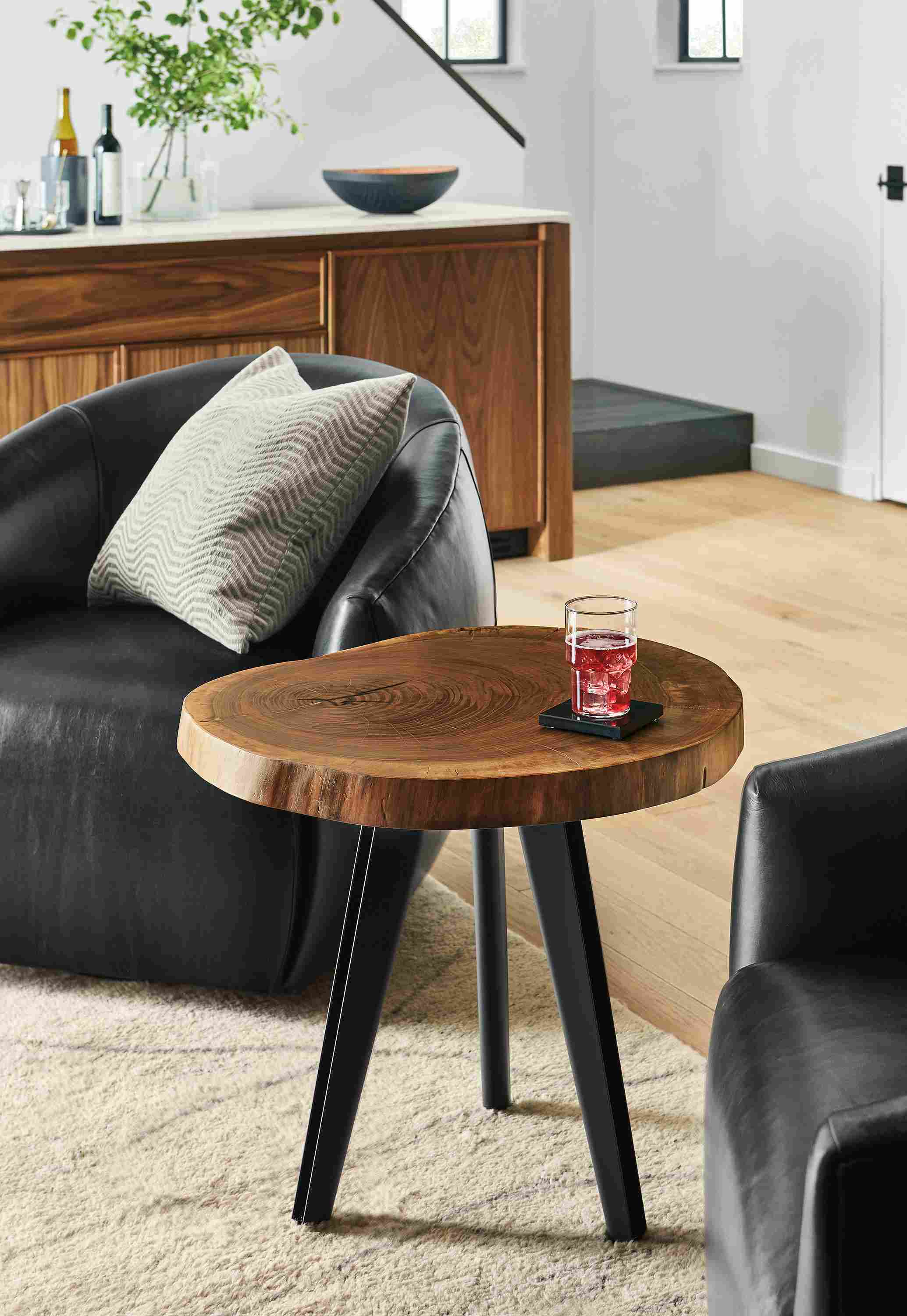 Living room with Mahoney end table in walnut and 2 Mora swivel chairs in Vento Black leather.