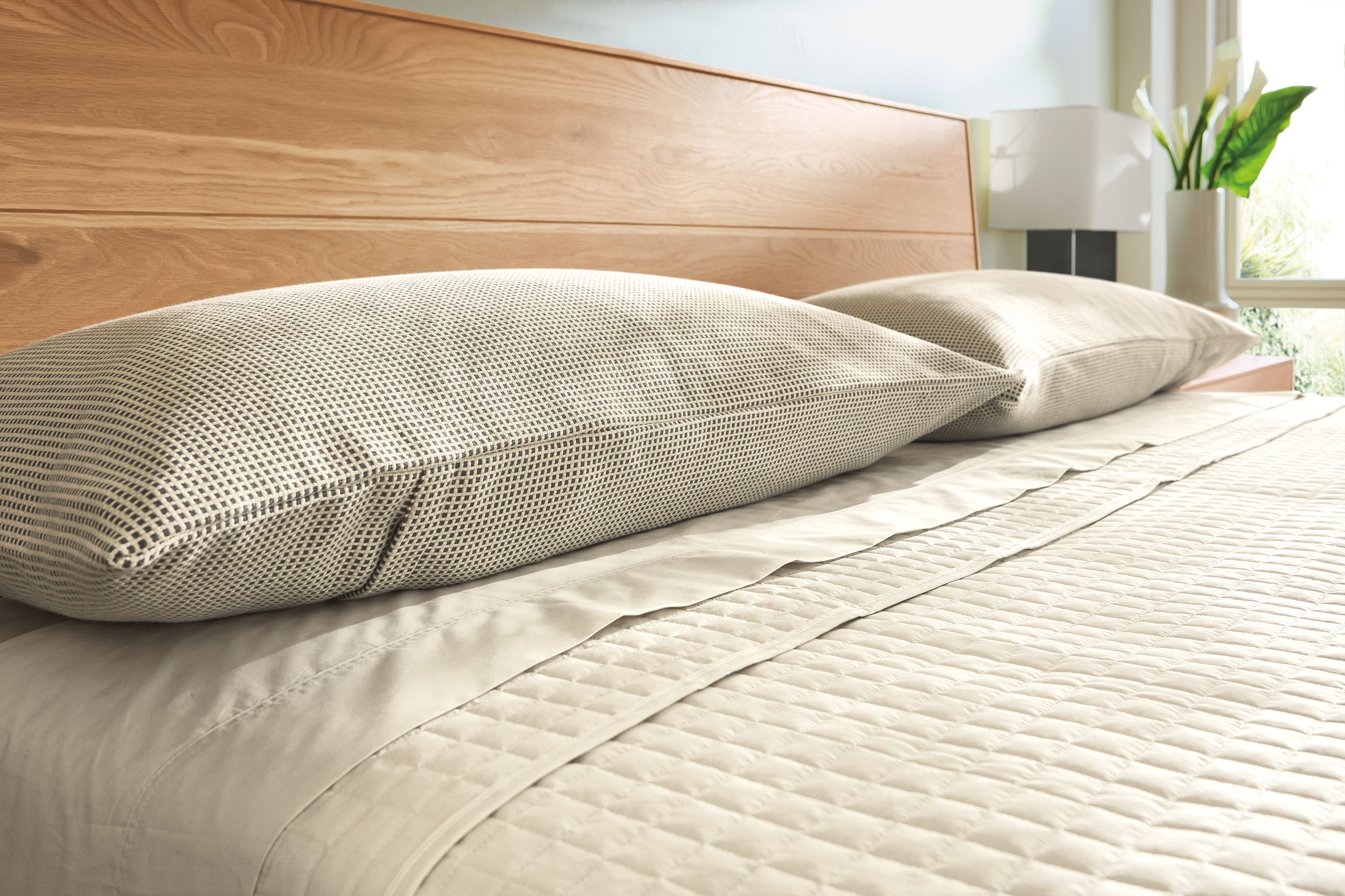Bedroom with detail of Mara king sham in ivory/grey and signature percale sheets and coverlet in Ecru.