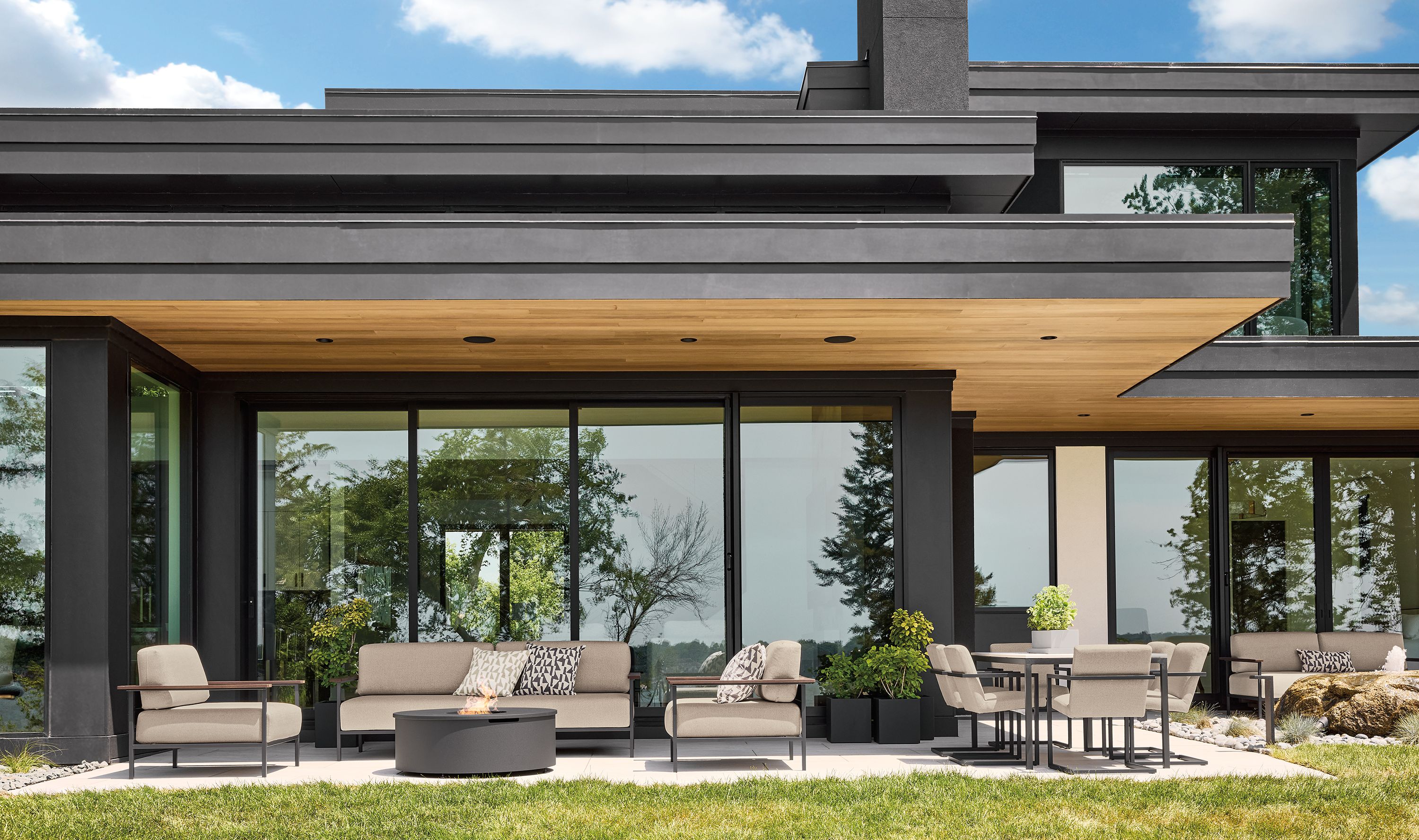 Large patio with Marin sofas and 2 lounge chairs in Mist Oatmeal and Adara round fire table in graphite.