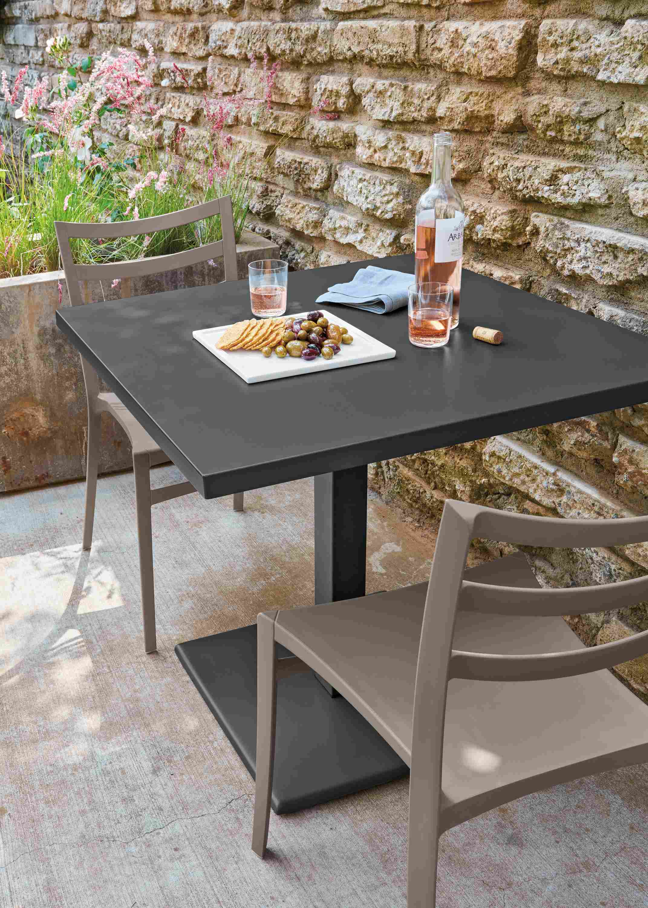 Detail of Maris square table in graphite and 2 Sabrina outdoor dining chairs in taupe.