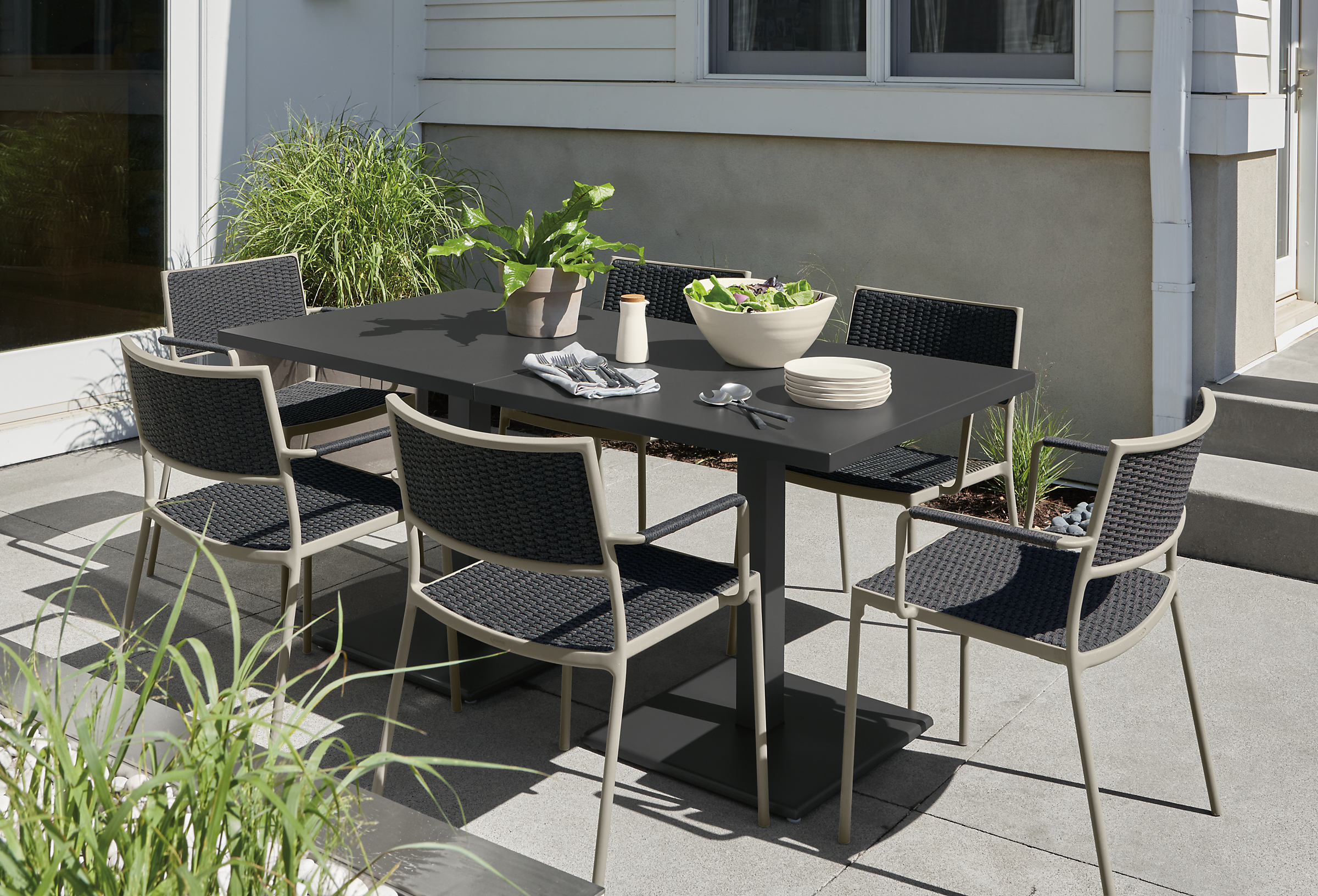 Two Maris 32-square outdoor tables in graphite with Plat chairs in Slate with taupe frame.