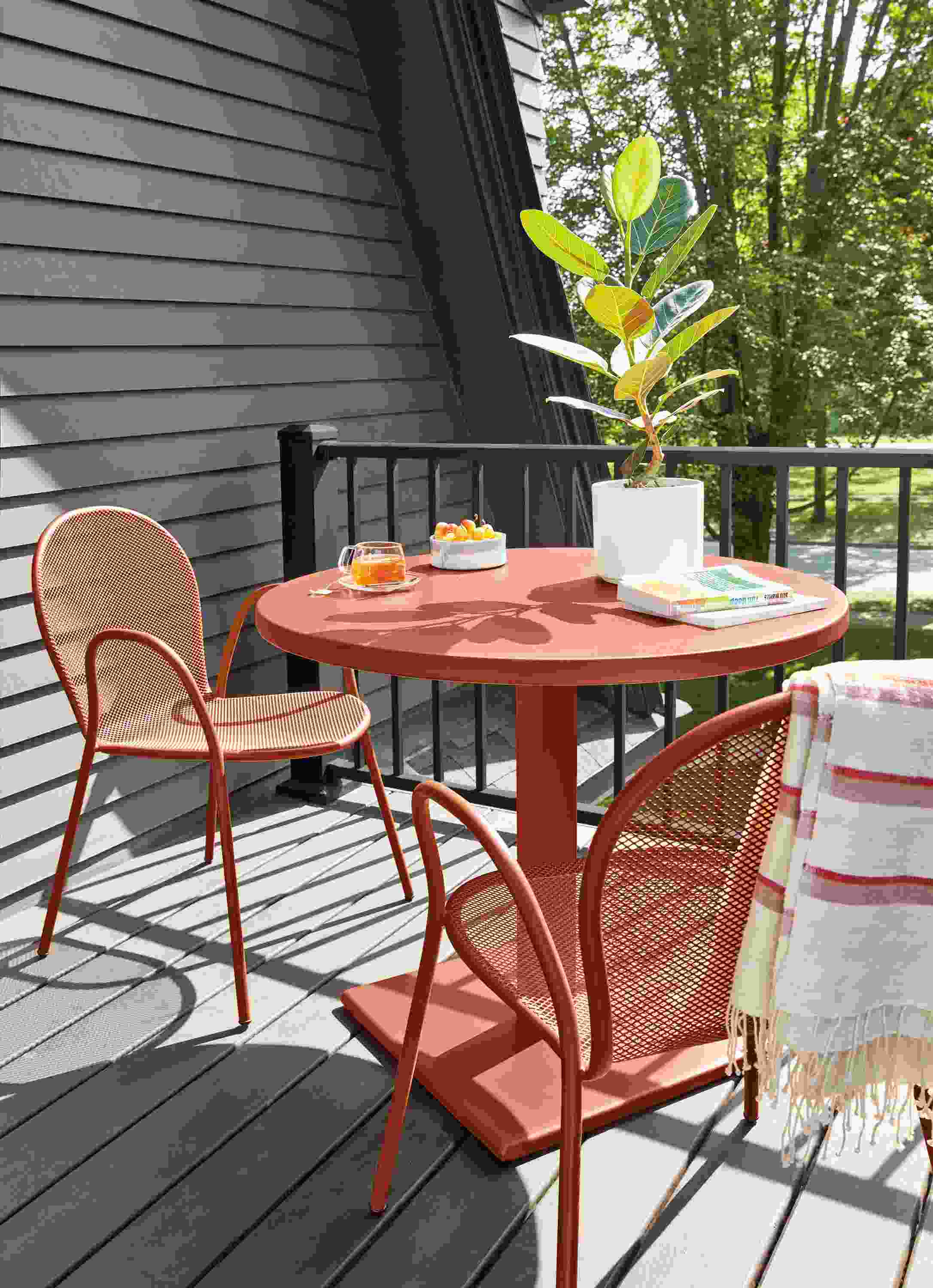 Outdoor deck with Maris round table and two Rio chairs in Cognac.
