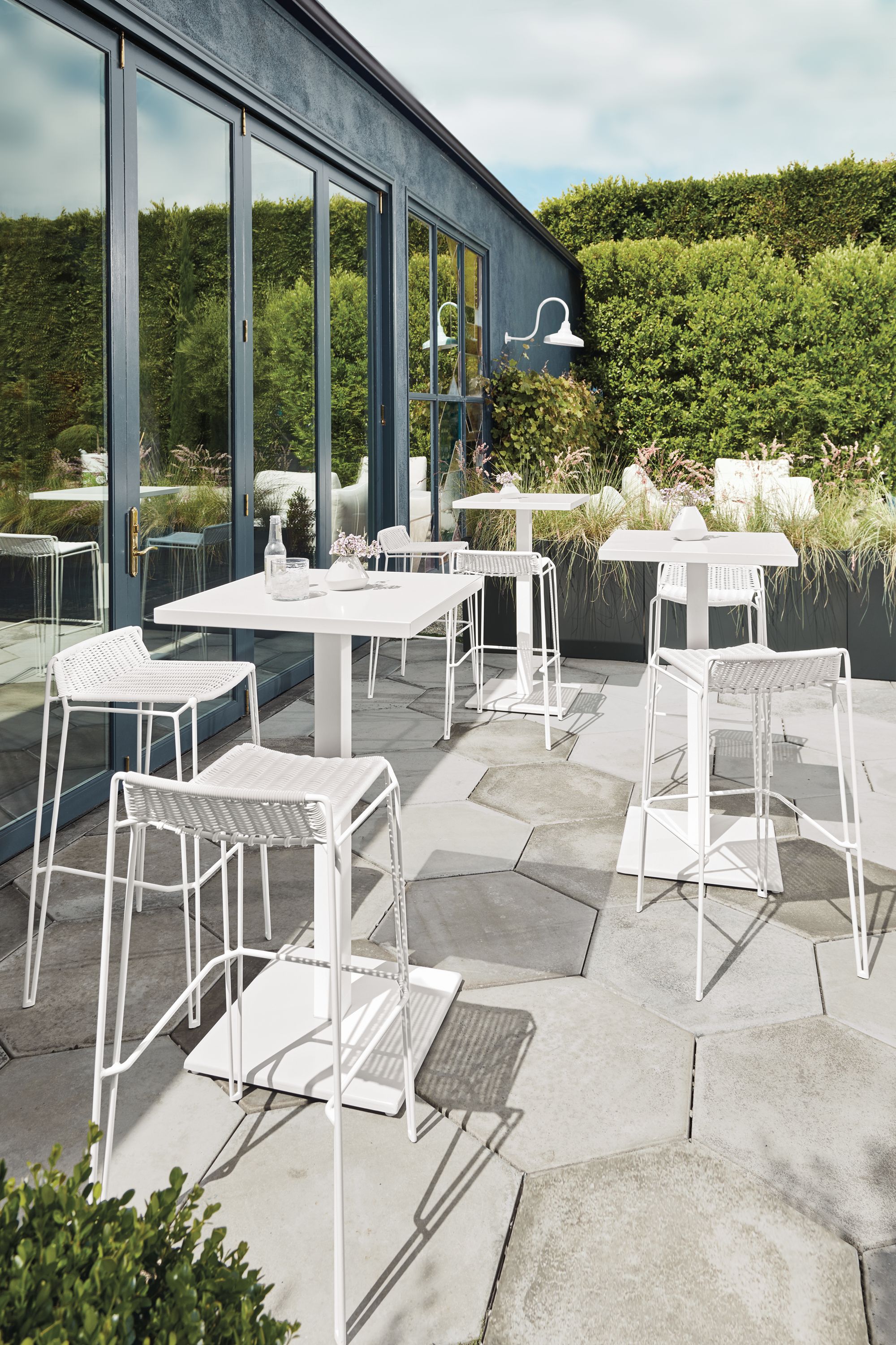 Patio with Maris square bar tables and Penelope bar stools all in white.