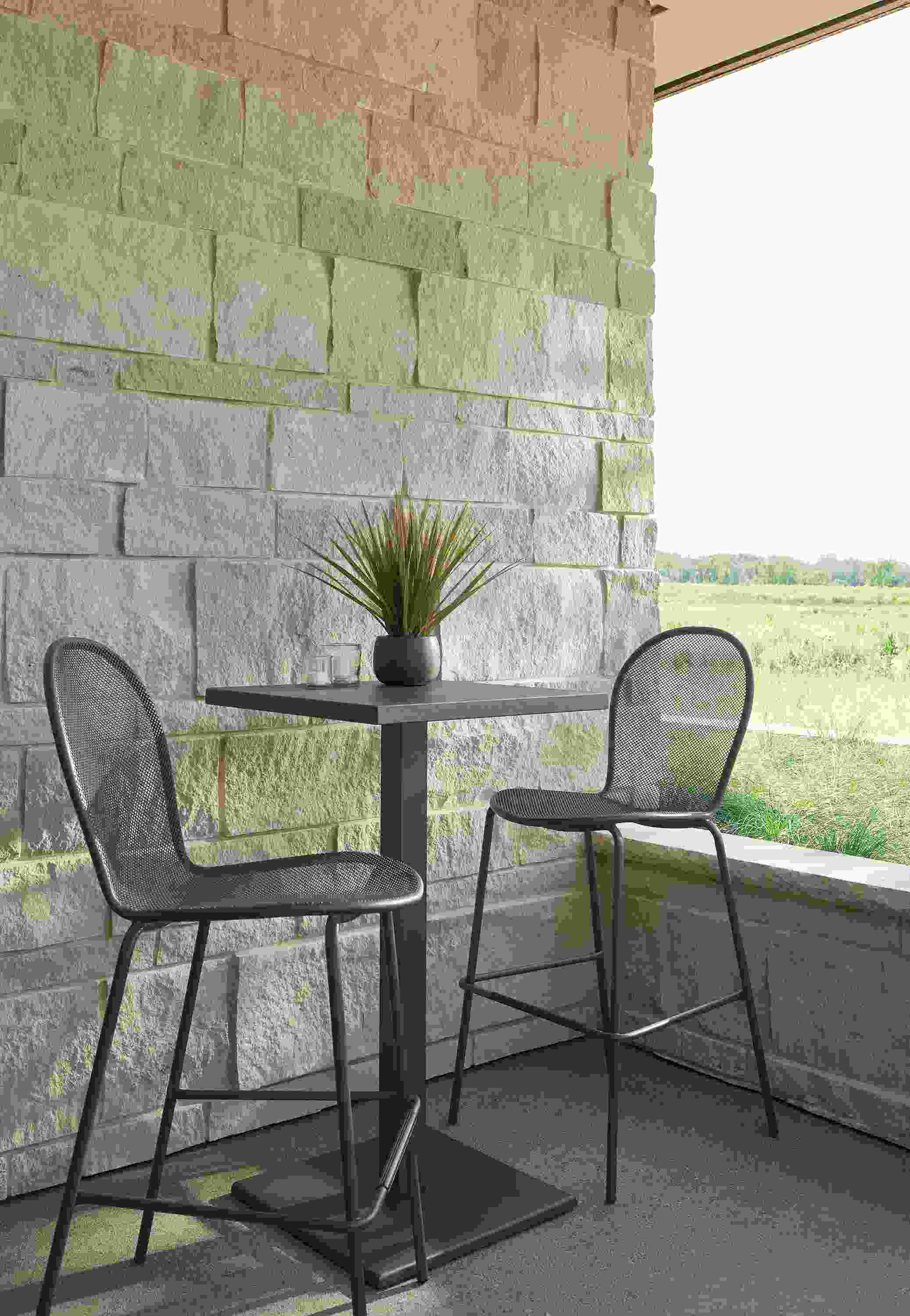 Patio with Maris square bar table and 2 rio bar stools in graphite.