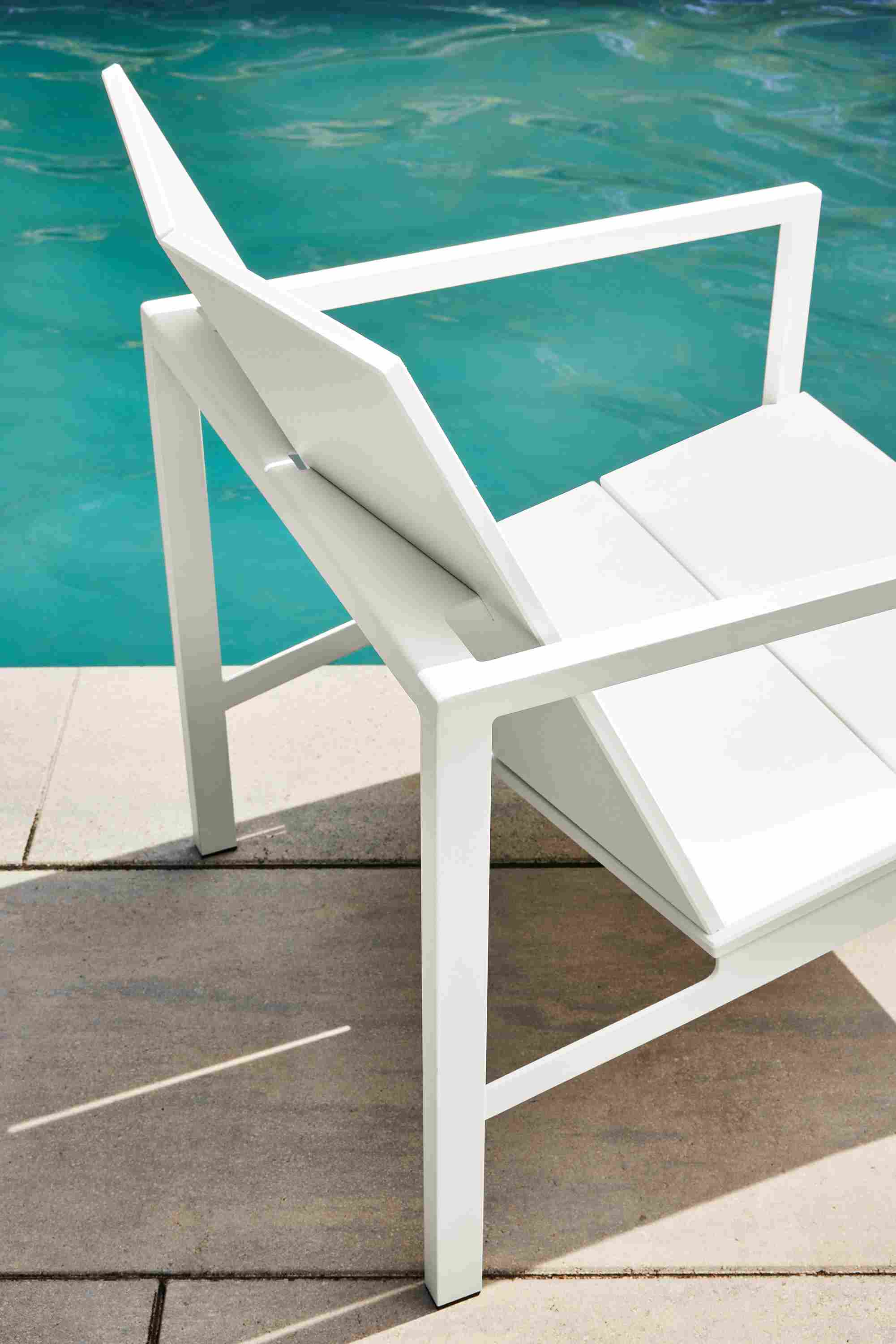 one mattix chair in white besides a pool.