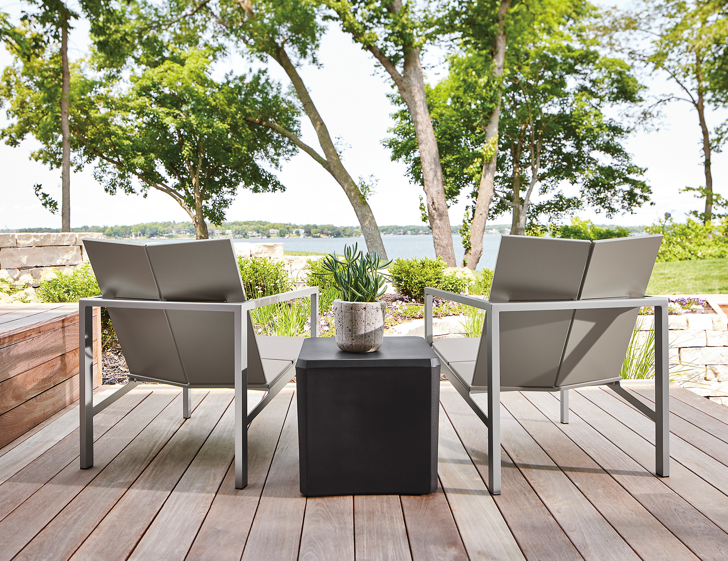 Outdoor deck with two mattix lounge chairs and a cusp square stool.