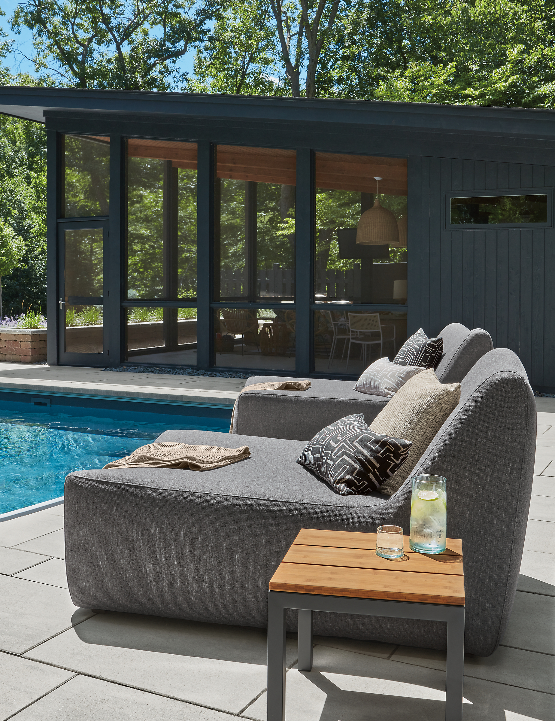 Two May outdoor chaise in Mist Charcoal with Parsons 18-square outdoor table in graphite with Bamboo top.