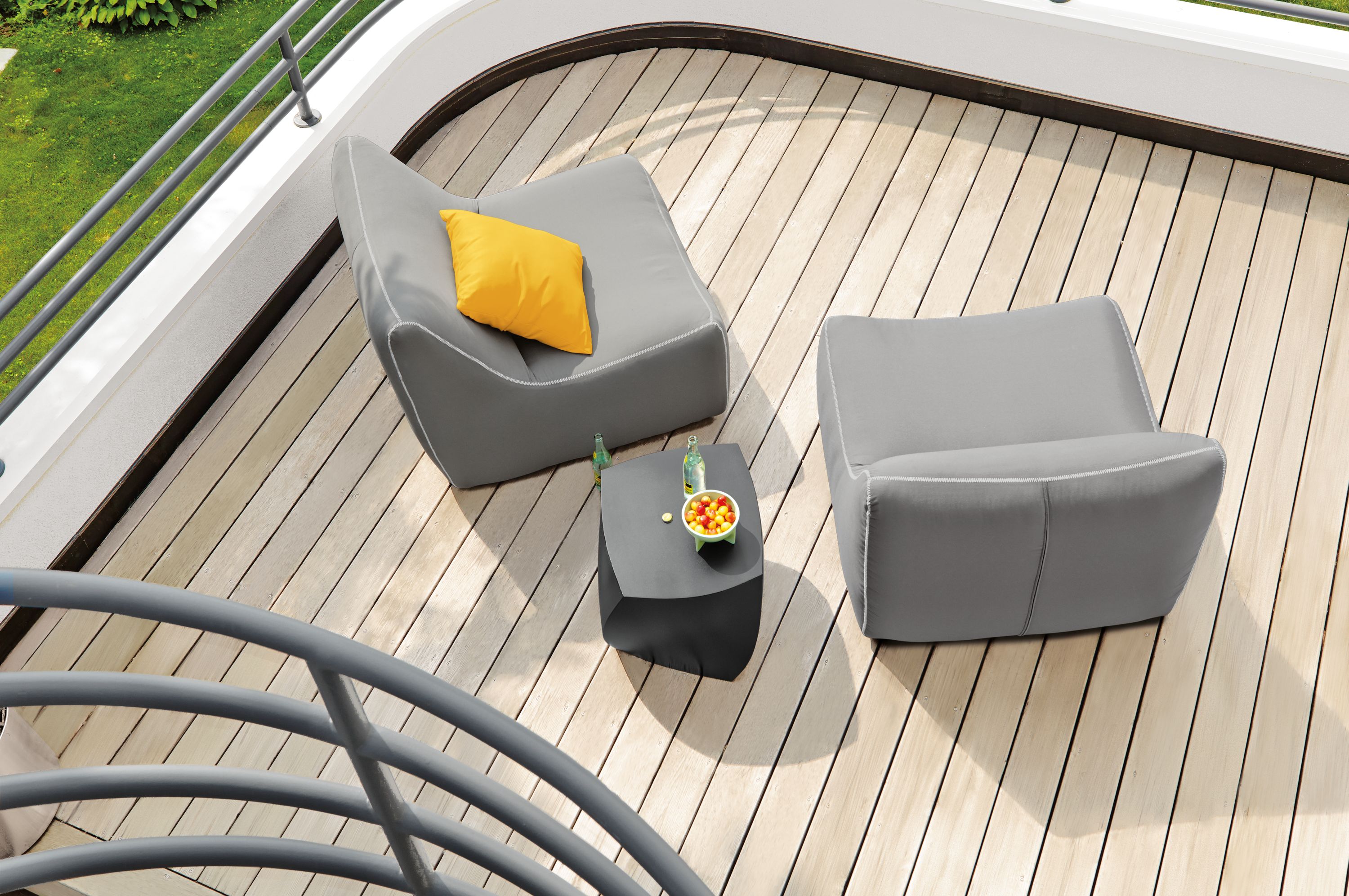 Overhead view of balcony with 2 Maya Armless Chair in Sunbrella Canvas Charcoal and a Gehry left twist Cube in black.