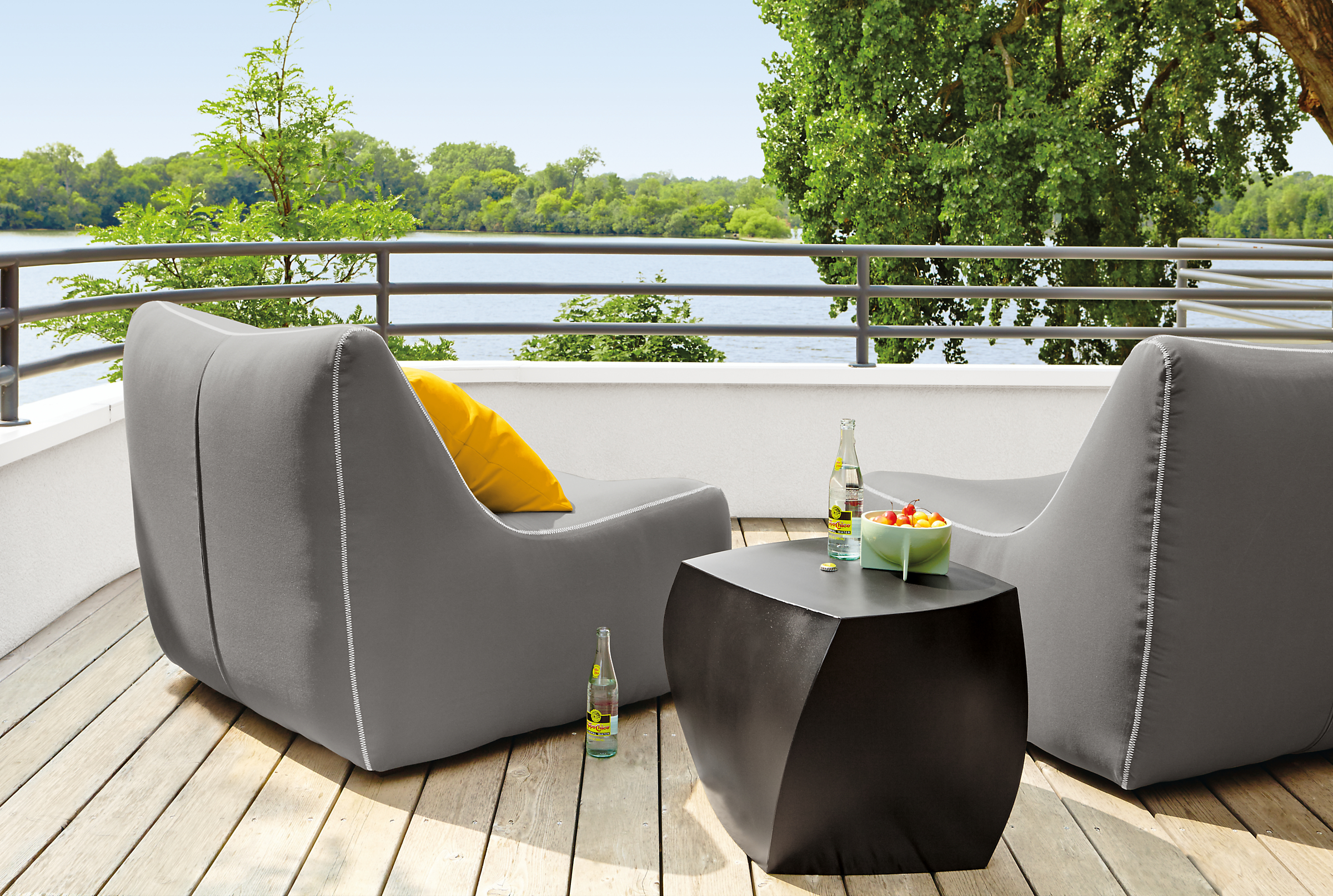 Outdoor balcony with 2 Maya Armless Chair in Sunbrella Canvas Charcoal and a Gehry left twist Cube in black.