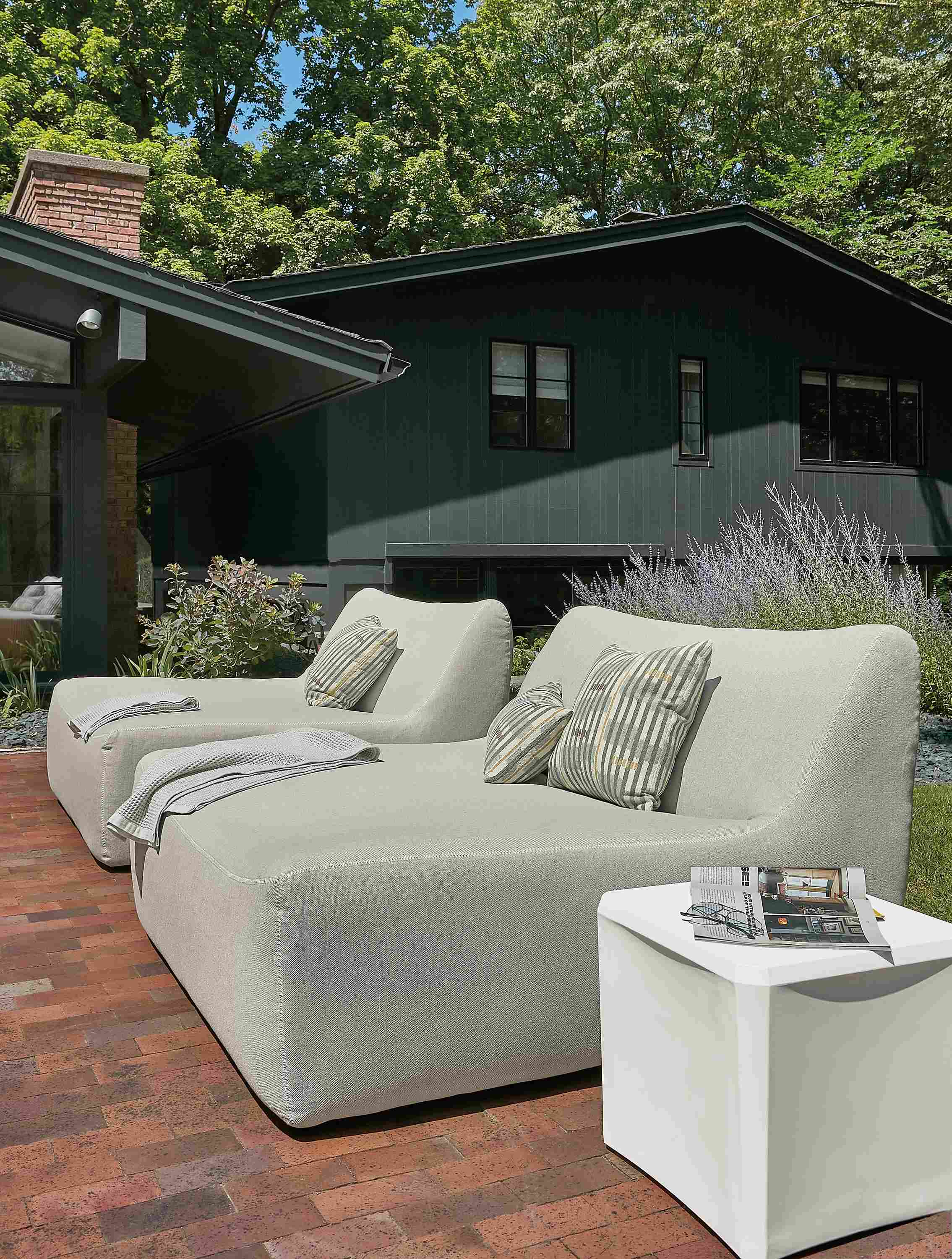Outdoor space with two large maya chaises in mist grey fabric.