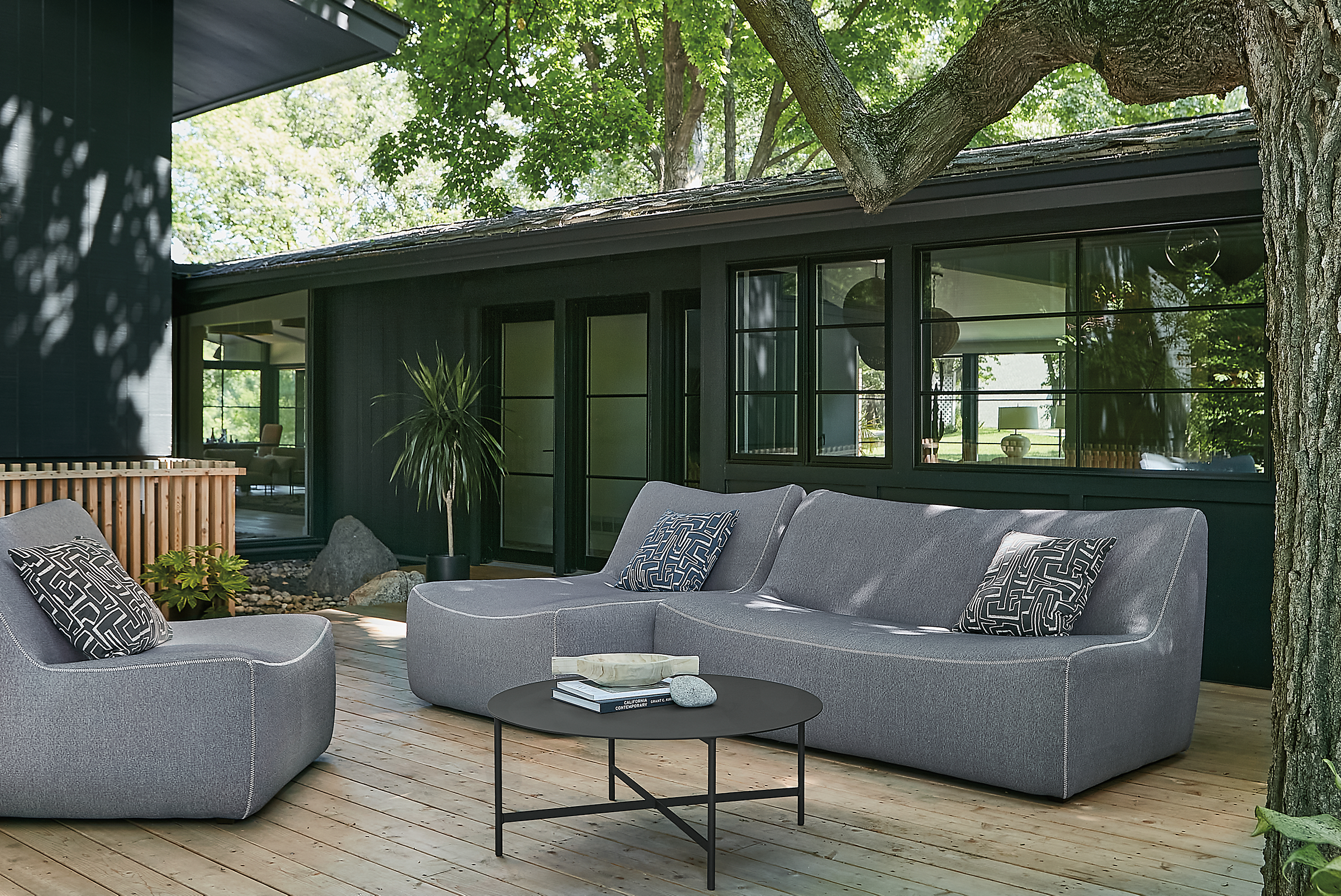 Outdoor space with maya two-piece modular sofa and maya chair, and circuit coffee table.
