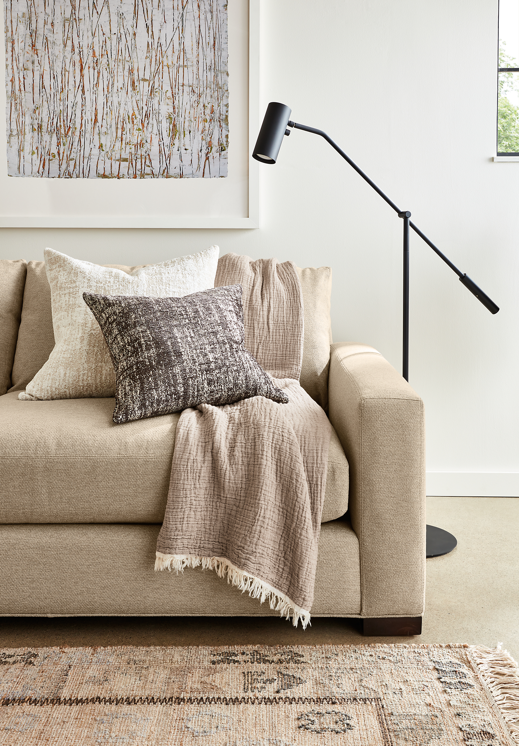Close-up of Metro Deep 98-wide Sofa in Tatum Fabric with Lisi Throw in Sand and 2 Briget throw pillows.