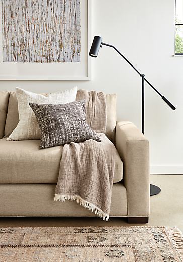 Close-up of Metro Deep 98-wide Sofa in Tatum Fabric with Lisi Throw in Sand and 2 Briget throw pillows.  