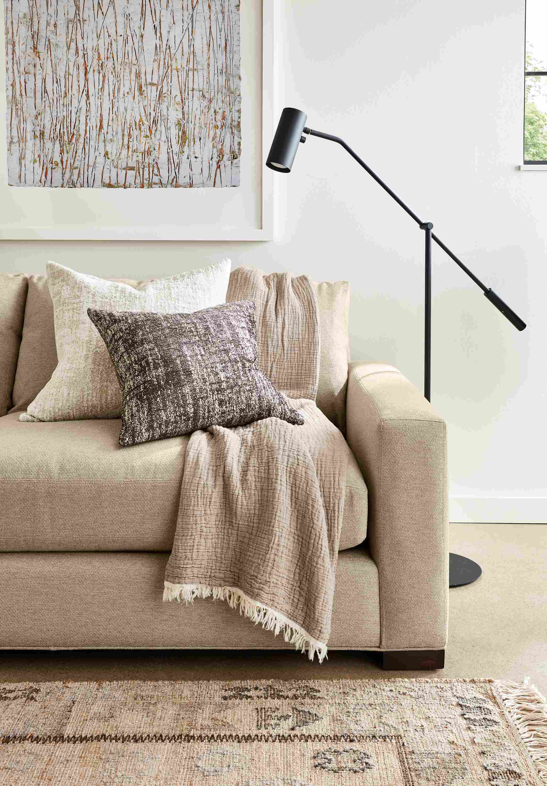 Close-up of Metro Deep 98-wide Sofa in Tatum Fabric with Lisi Throw in Sand and 2 Briget throw pillows.