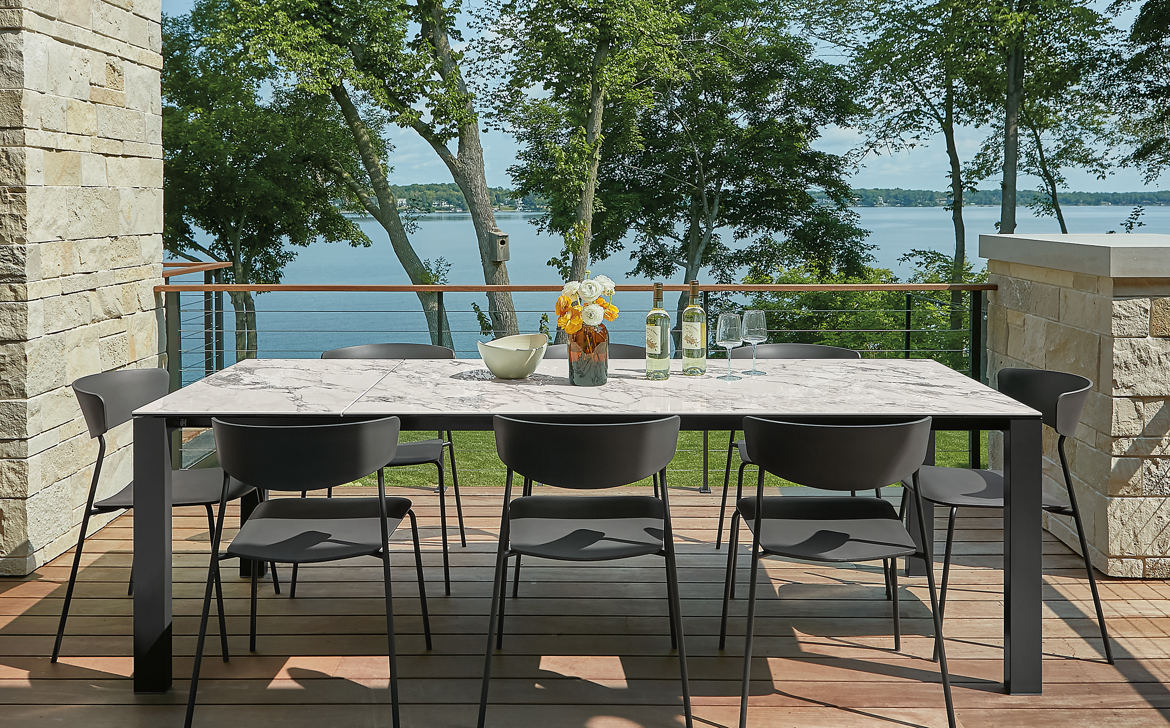 Outdoor space with metric outdoor extension table extended, and six wolfgang dining chairs.