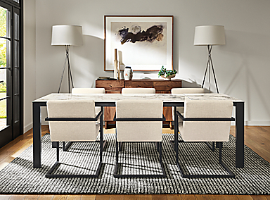 Dining room with Metric 72 wide extension table in graphite with marbled bright white ceramic top, Lira arm chair in Sumner Ivory, Nera 8 by 10 rug in coal, and two Tri-Plex floor lamp in polished nickel.