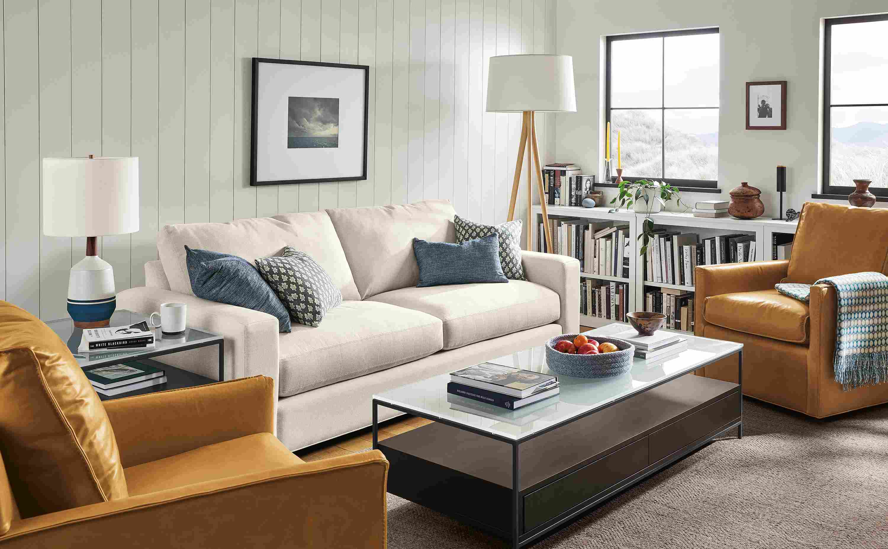 Living area with Metro sofa in Sumner Ivory, two Bram swivel chairs in Vento camel leather and Williams coffee table in charcoal.