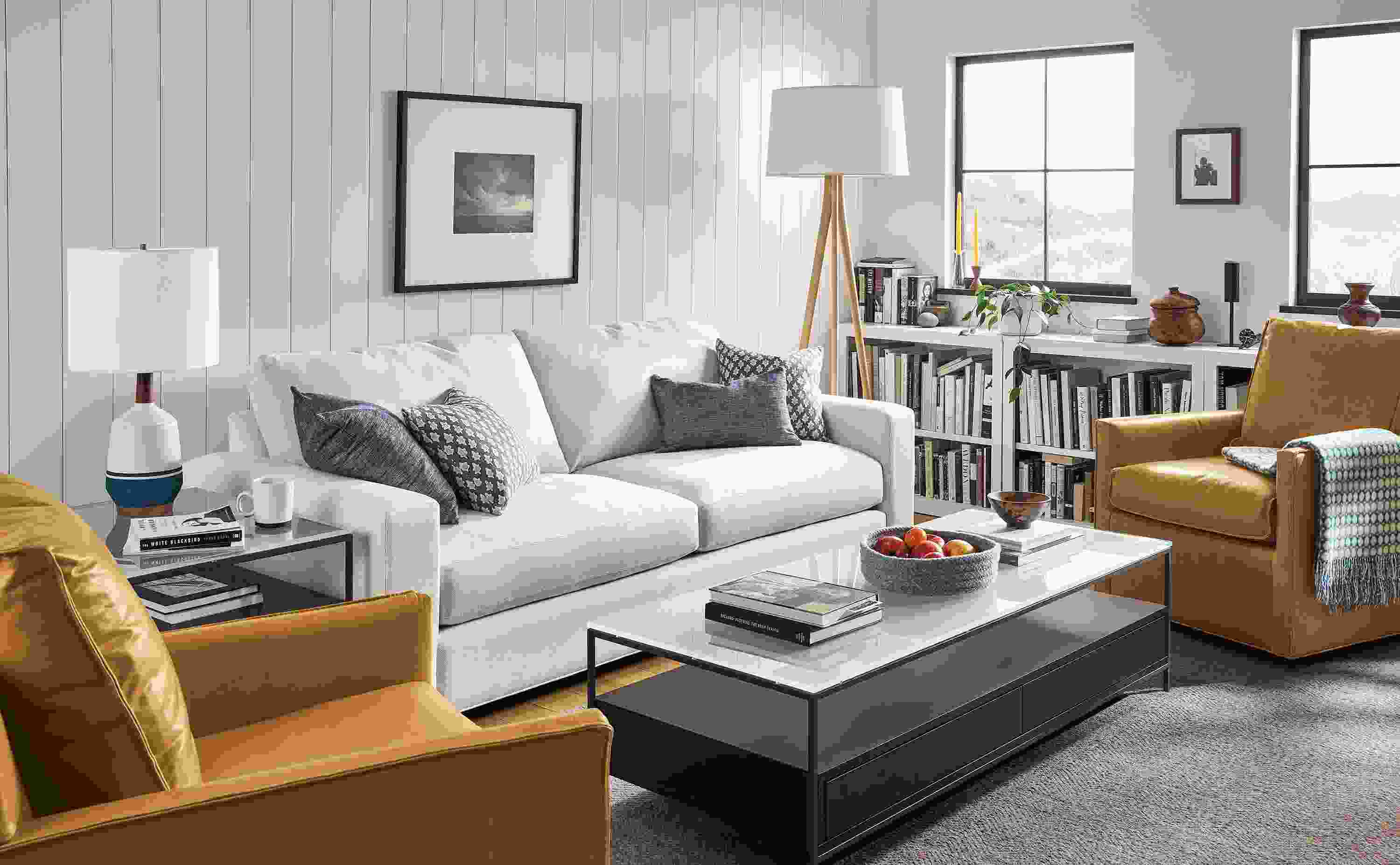 Living area with Metro sofa in Sumner Ivory, two Bram swivel chairs in Vento camel leather and Williams coffee table in charcoal.