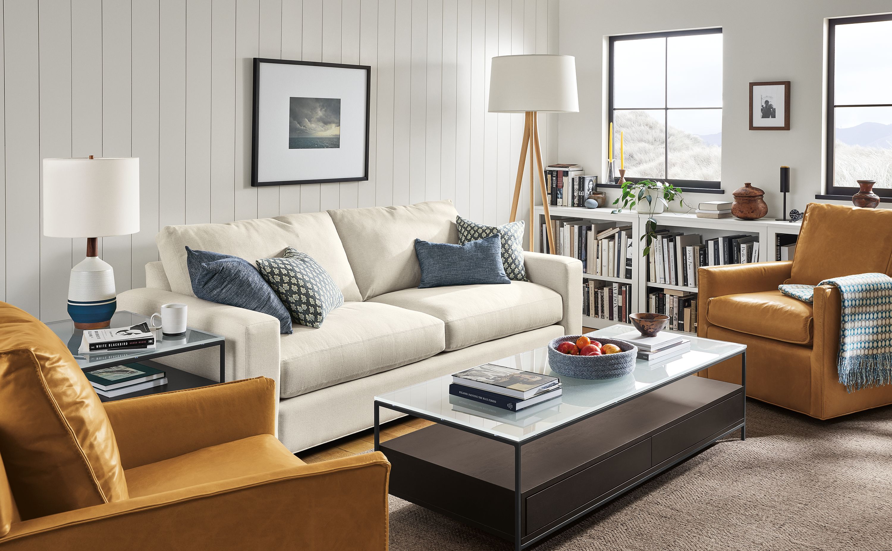 Living area with Metro sofa in Sumner ivory, two Bram swivel chairs in Vento camel leather and Williams coffee table in charcoal.