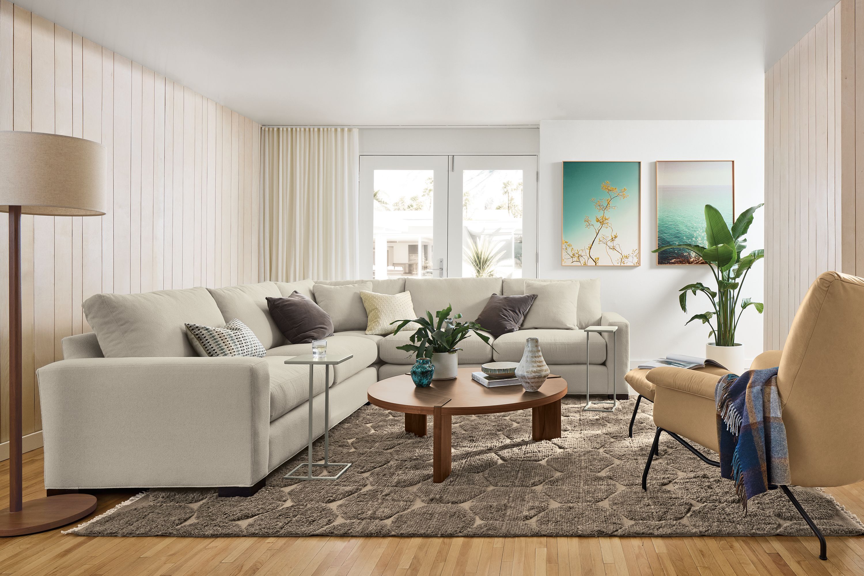 Living room with Metro 3-piece sectional in Declan Natural, Paris Chair and ottoman in Fiero Camel leather and Edo rug.