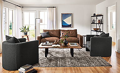 Living room with 88w Metro sofa in Laino Cognac leather, silva chairs in Declan Graphite and Kalindi rug in charcoal.