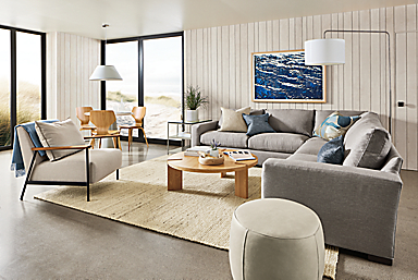 living room with metro sectional sofa in gino cement, xavier chair, lind ottoman and hanover coffee table in white oak.