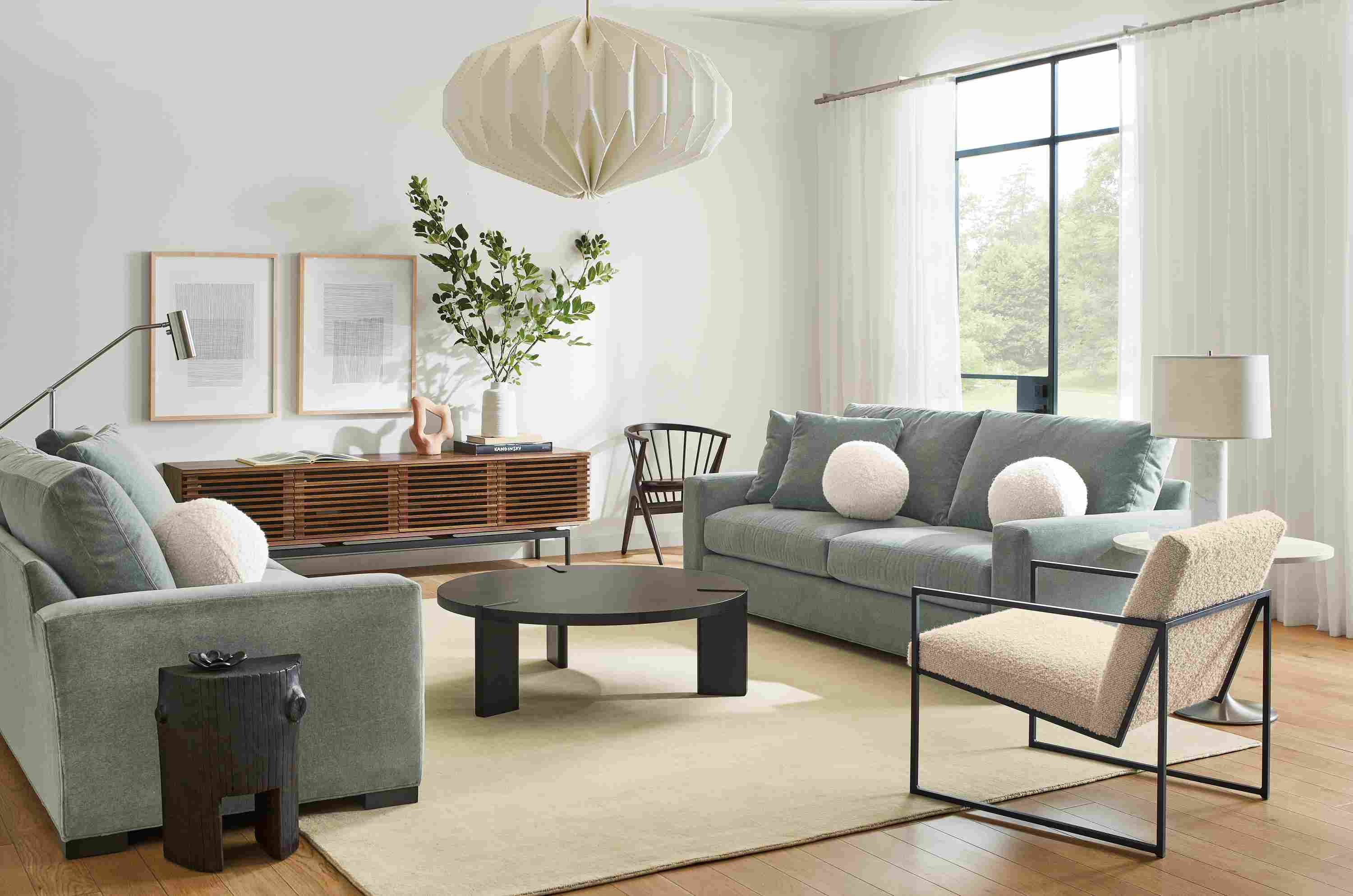 Living room with two Metro 88-inch Sofa in Vick Lead, Novato chair in Dornick Ivory and Hanover 42-round coffee table.