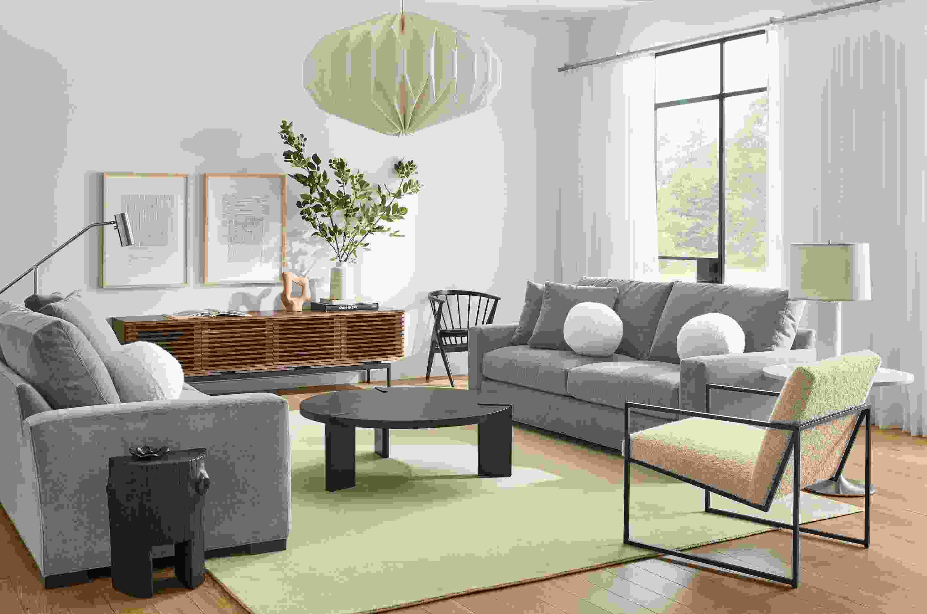 Living room with two Metro 88-inch Sofa in Vick Lead, Novato chair in Dornick Ivory and Hanover 42-round coffee table.