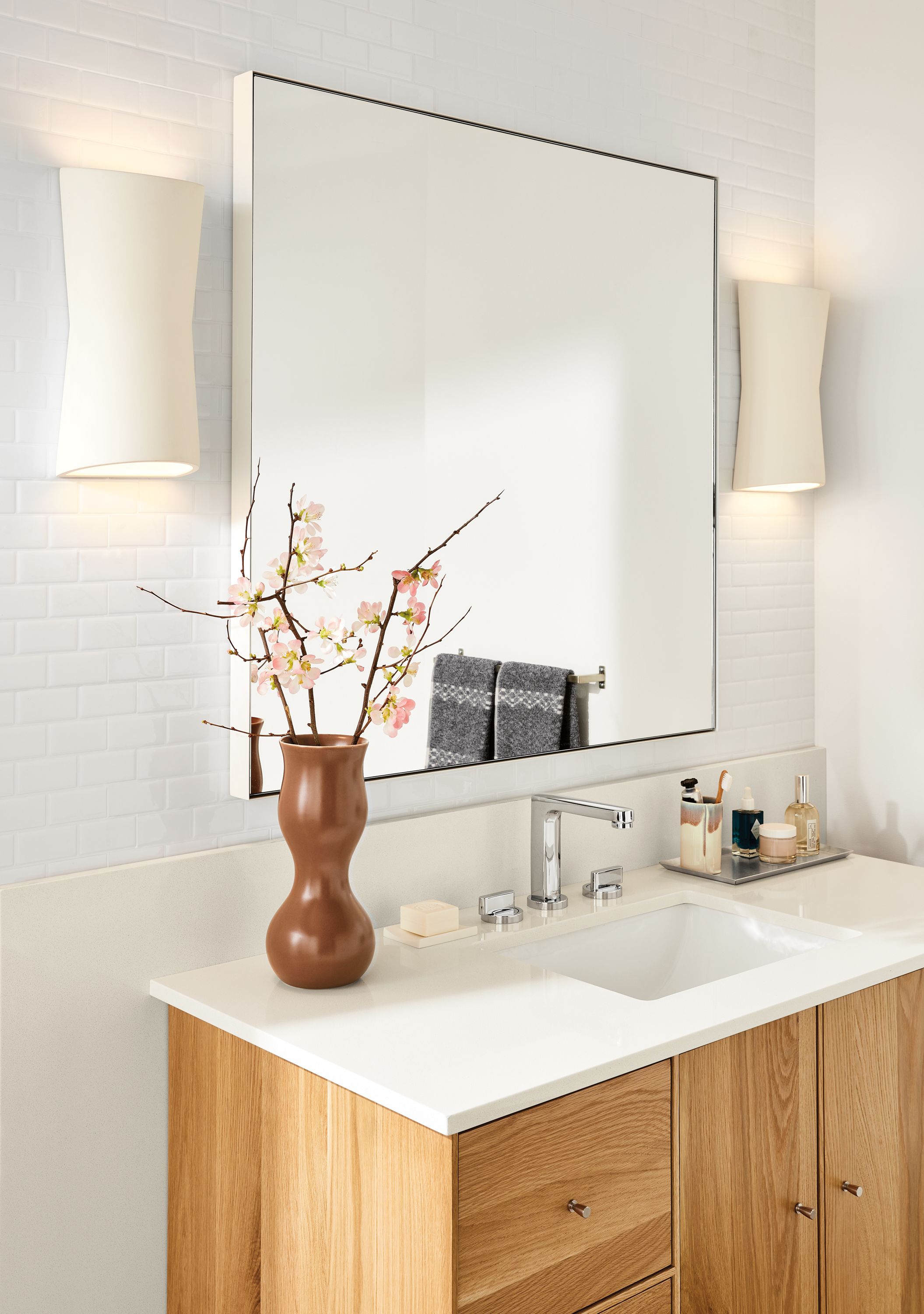 Bathroom setting with two Mezzo wall sconces and an Infinity mirror in white above a Hudson 48-wide bathroom vanity.