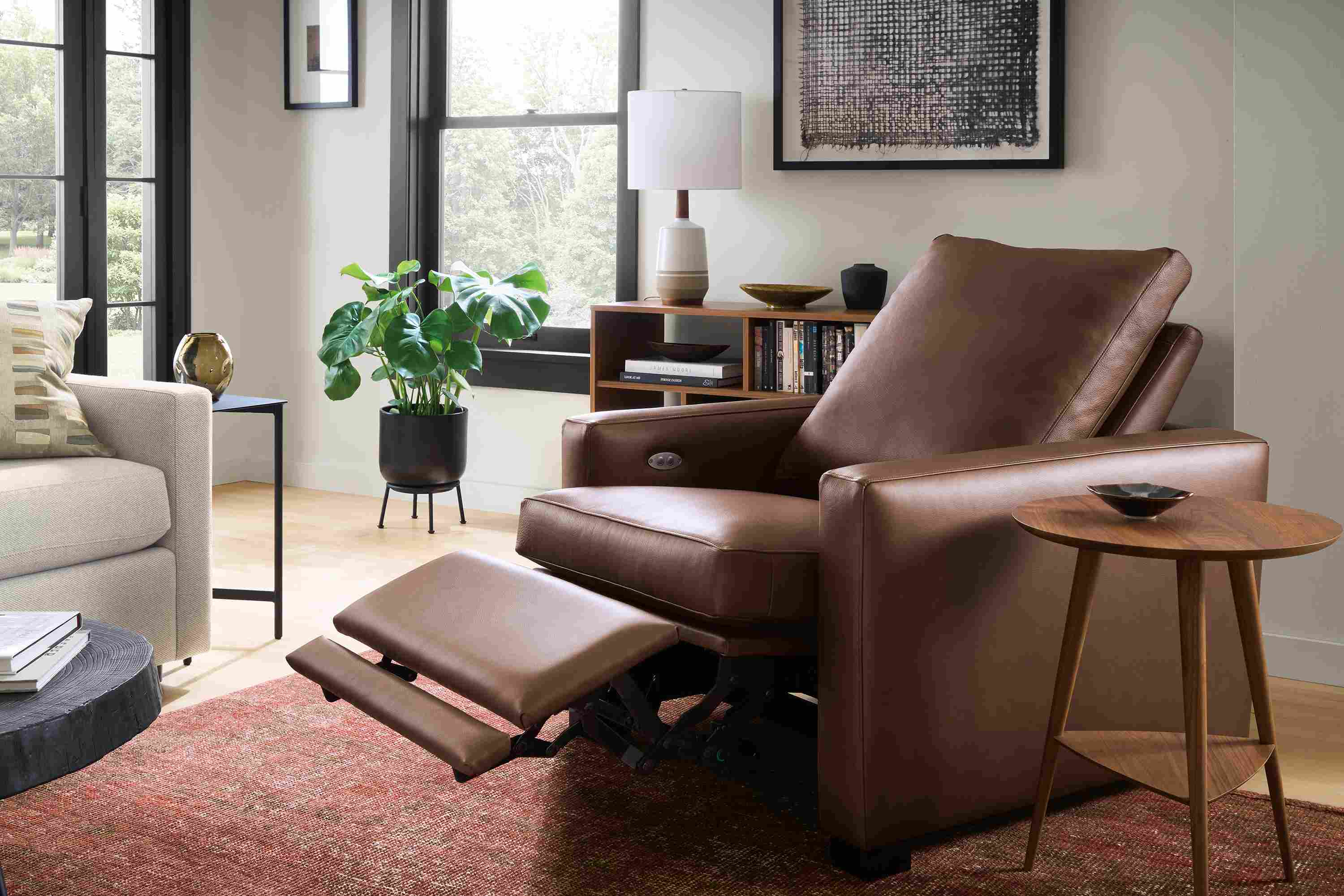 Living room with milton large power recliner in laino cognac shown in reclining position and amira 8 x 10 rug in brick.
