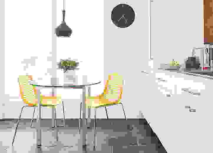 Dining area with Mini side chairs in yellow with chrome legs and Parsons 36-round table in Stainless steel and glass.
