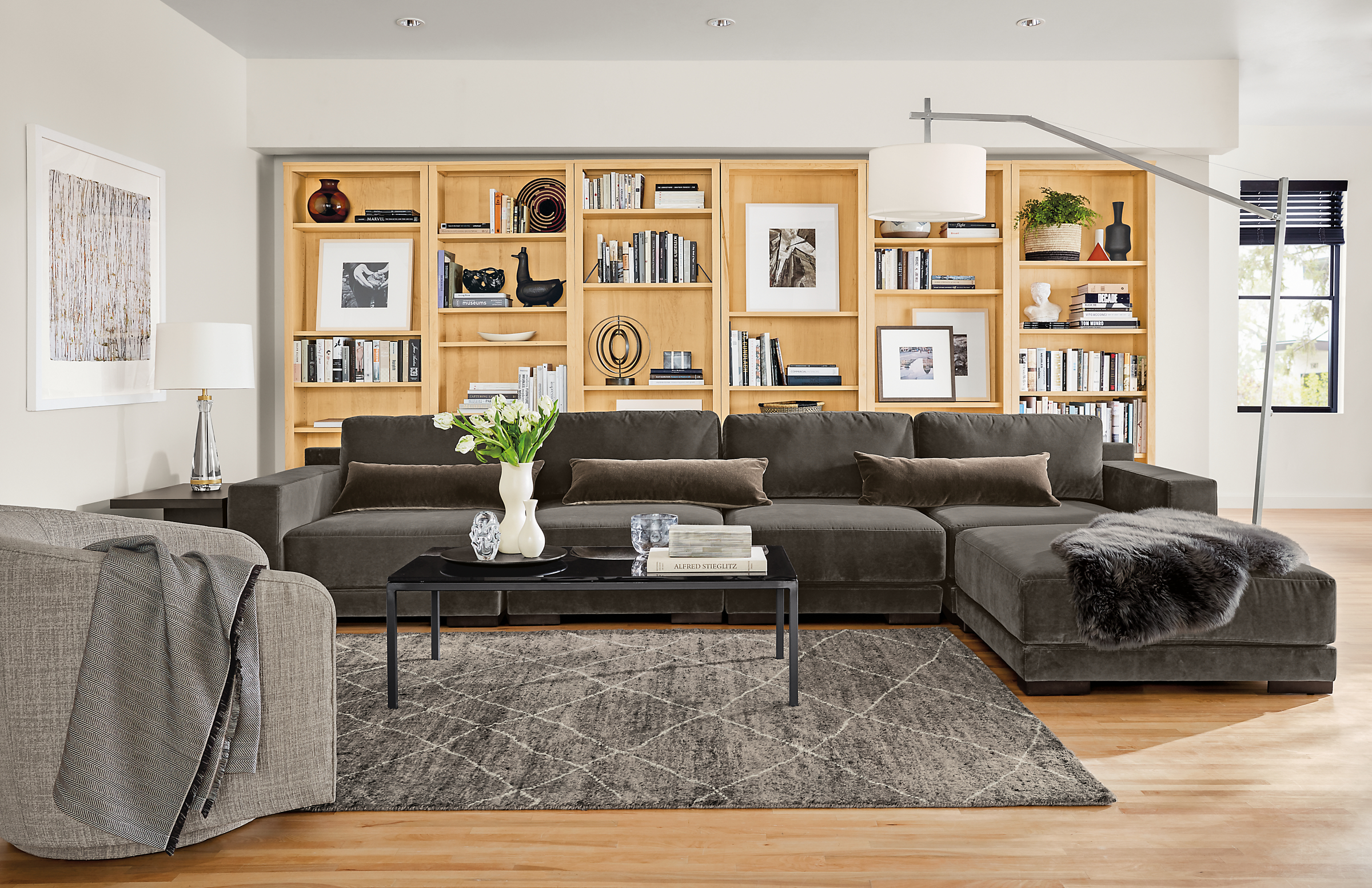 Detail of Mira 5-piece modular sectional in living room with woodwind bookcases in white oak.