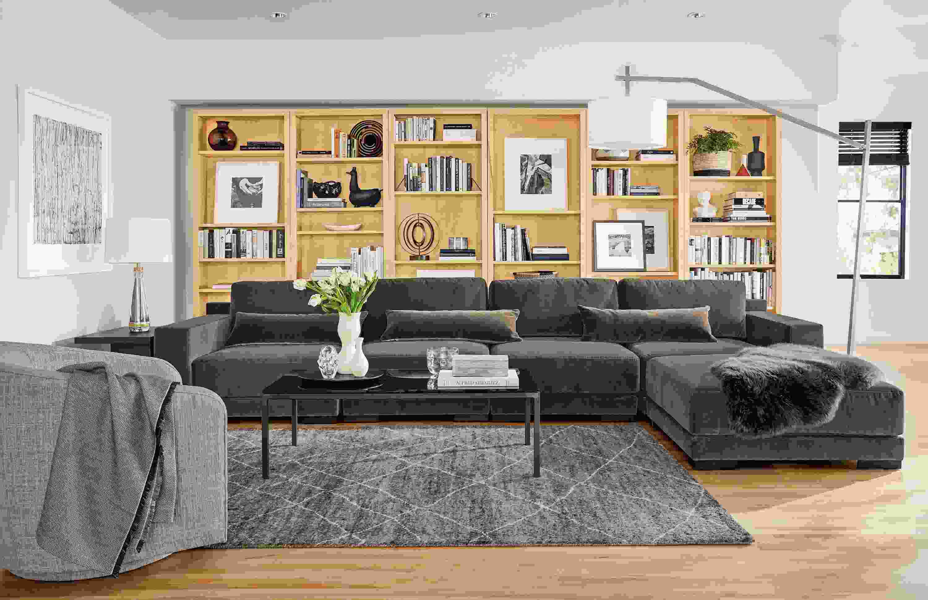 Detail of Mira 5-piece modular sectional in living room with woodwind bookcases in white oak.