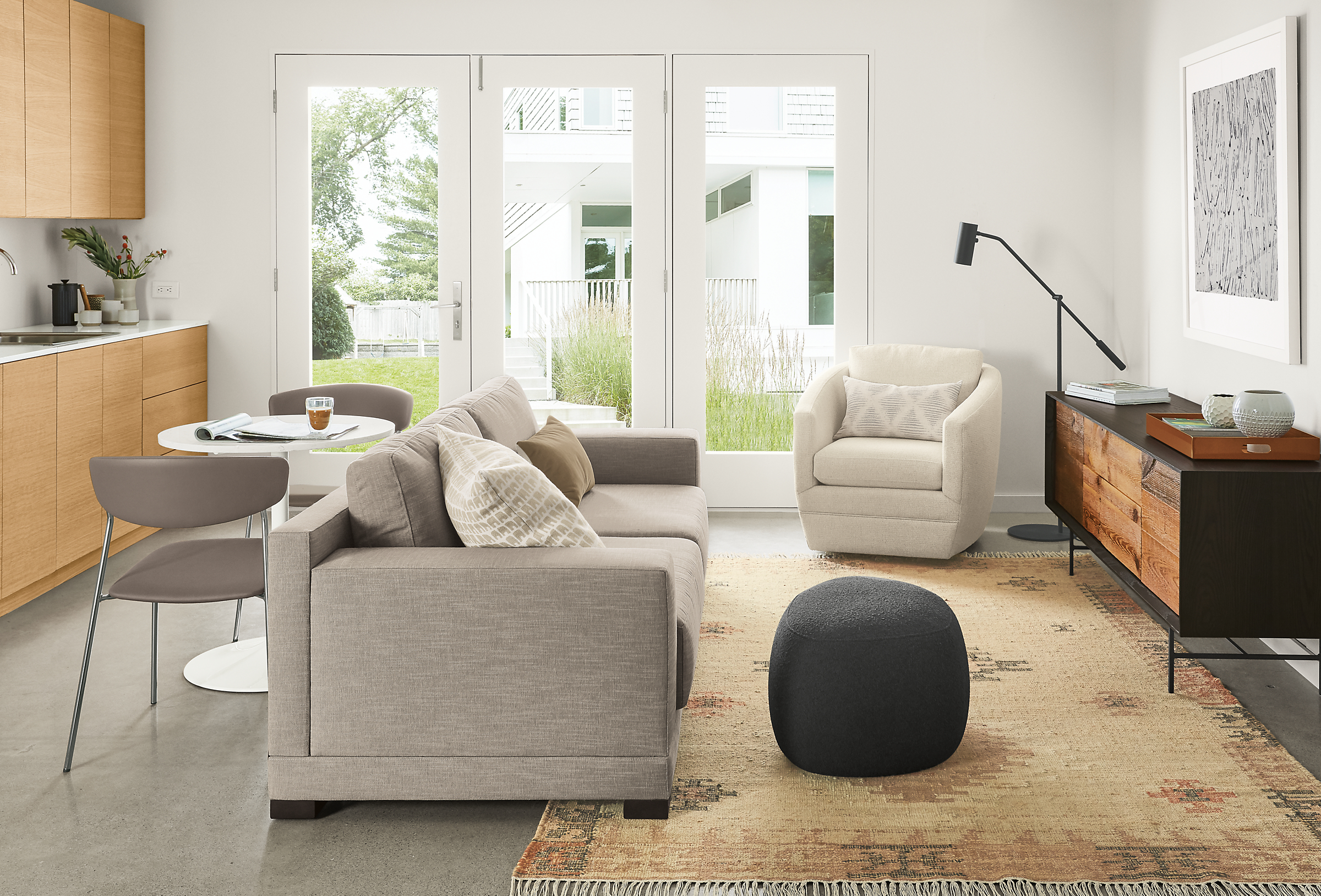 Side view of Mira sofa in Destin Putty fabric in small living/dining space.