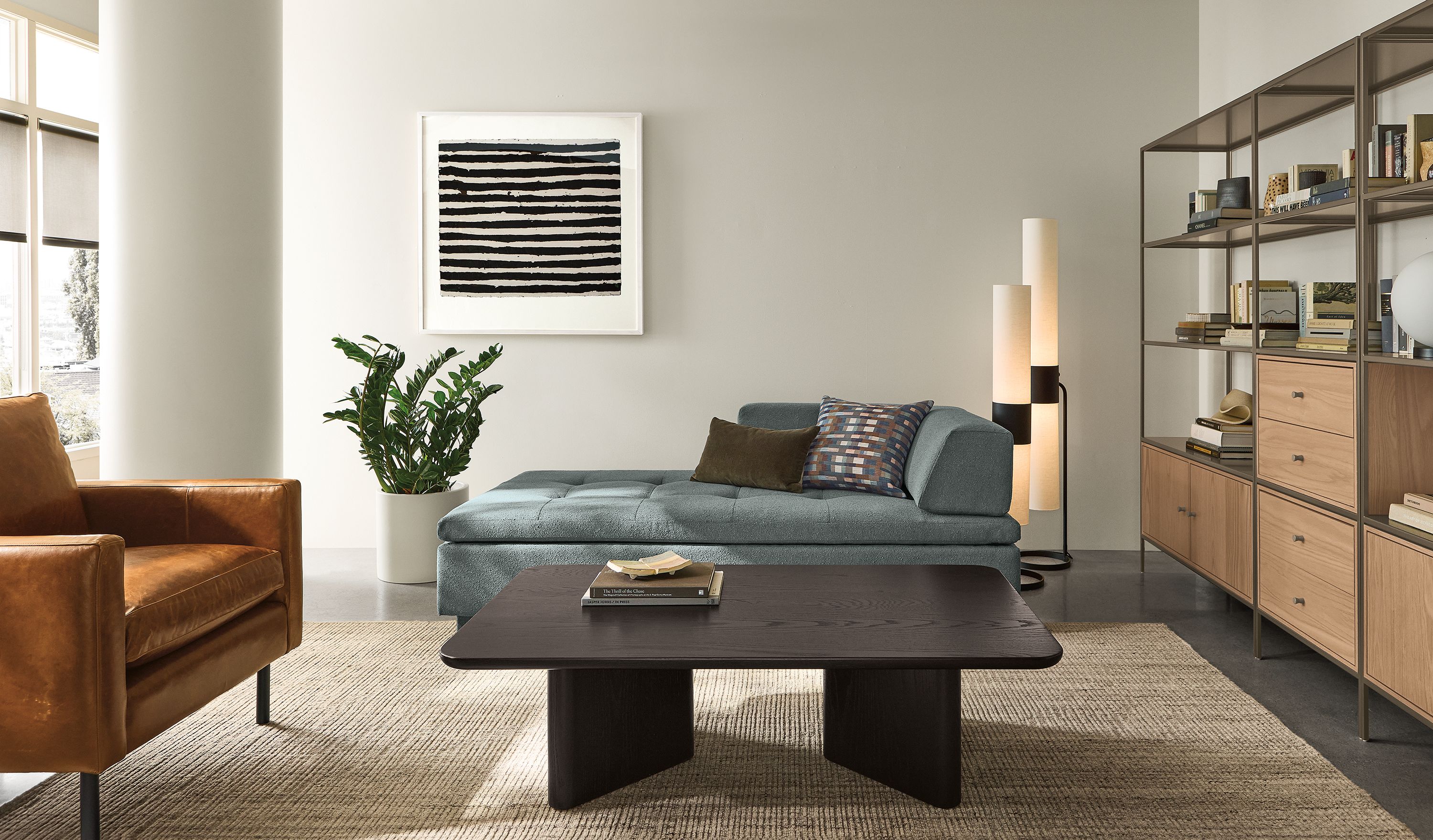 Living room with Miranda 76-wide daybed in declan haze, Jasper chair in vento cognac leather and carver coffee table in charcoal.