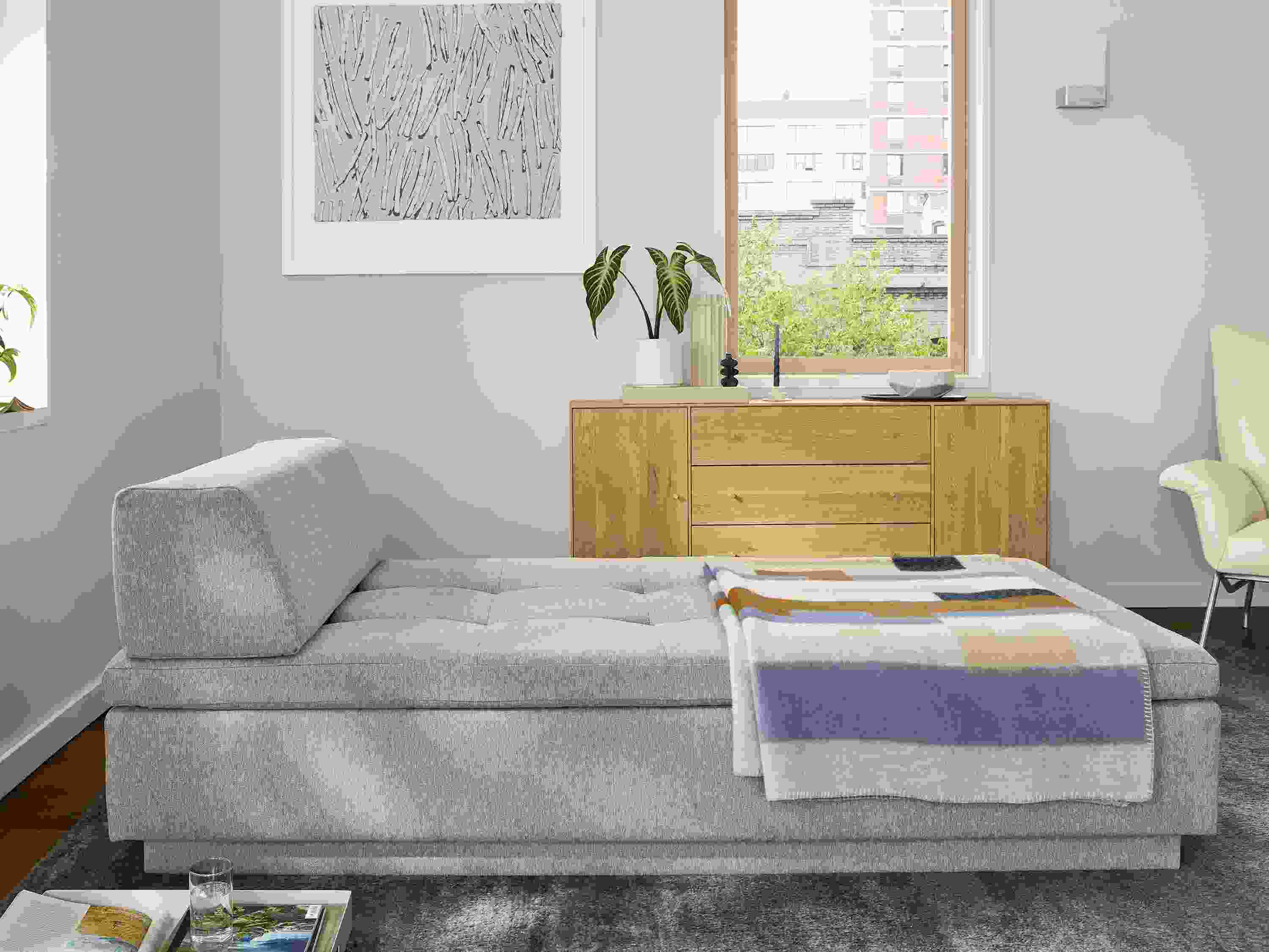 Living area with Miranda daybed with chaise in down position and Hudson storage cabinet in White Oak.