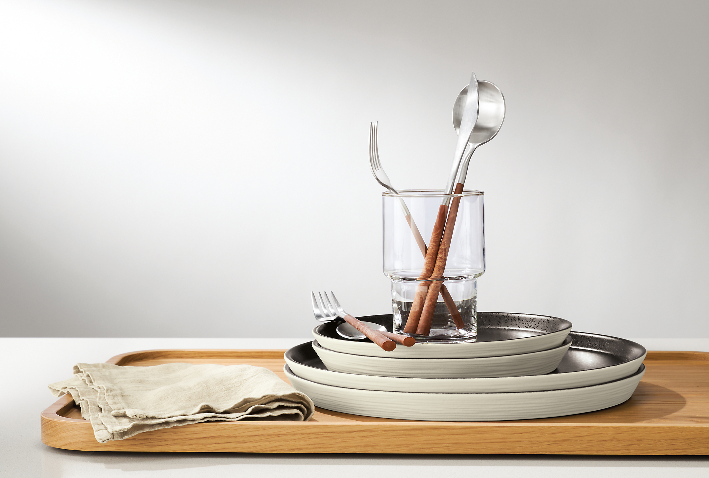 detail of notos plates and mito flatware on aspect wood tray.
