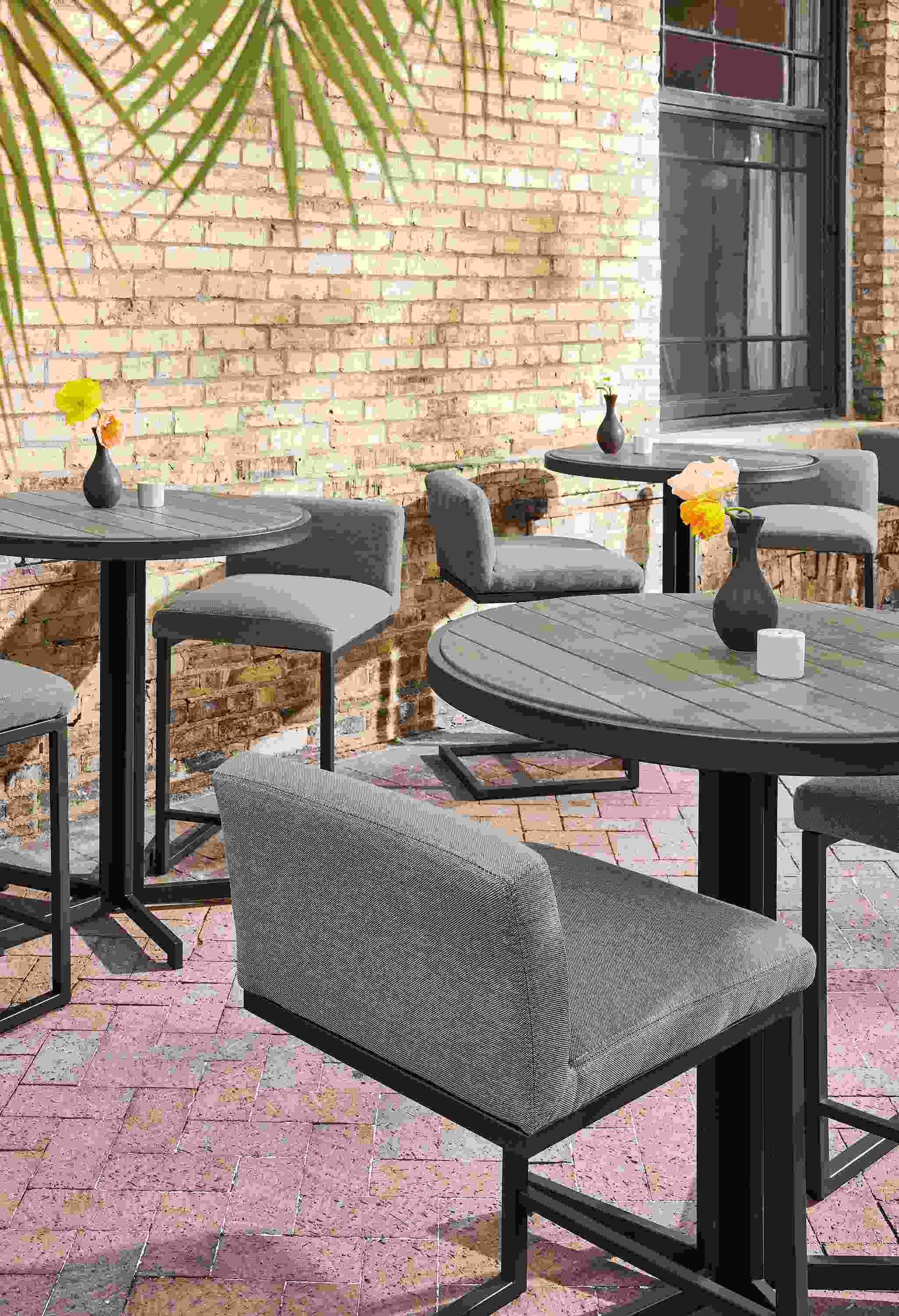 Outdoor dining space with montego round counter tables in aged thermally modified oak and finn counter stools.
