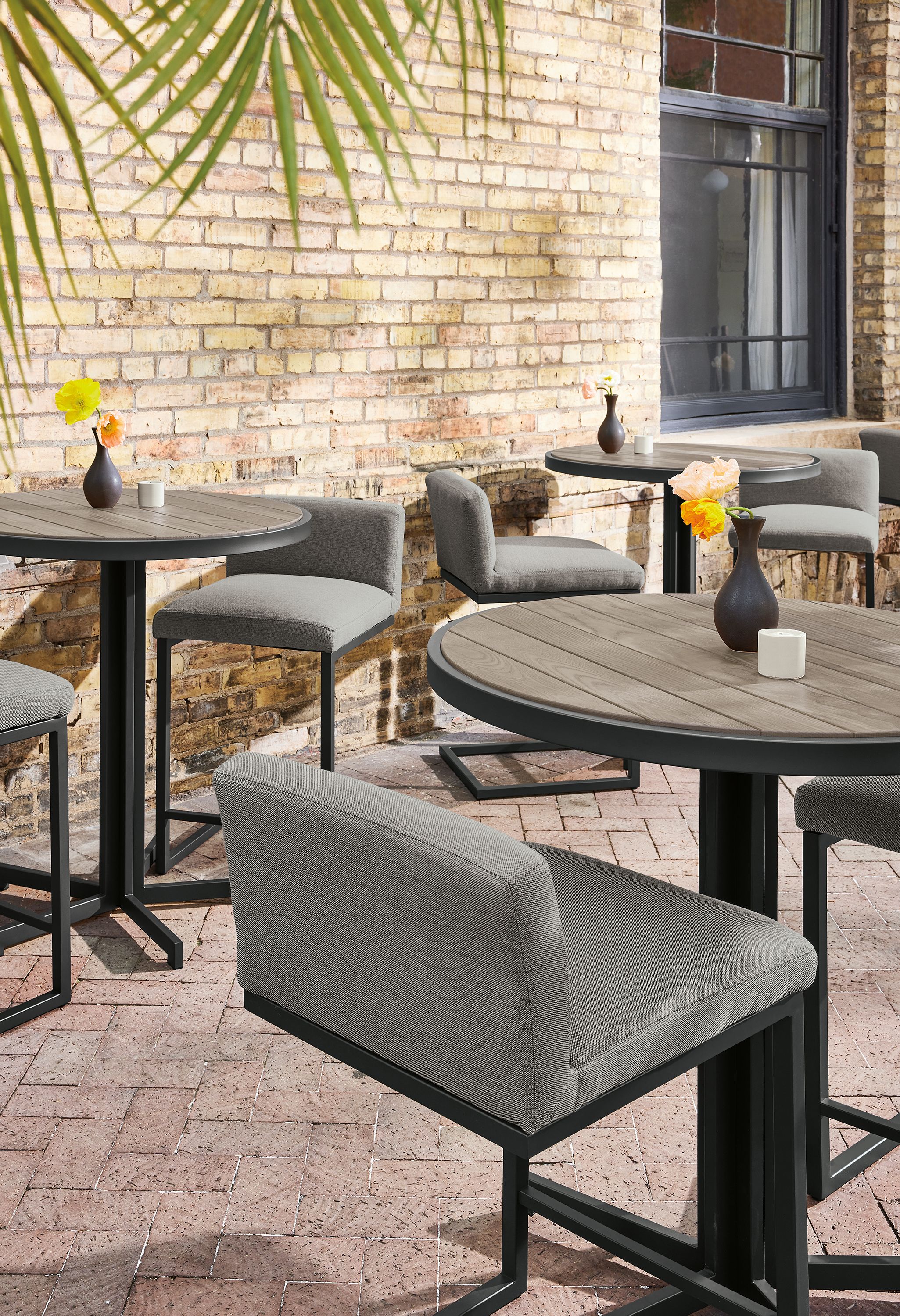 Outdoor dining space with montego round counter tables in aged thermally modified oak and finn counter stools.