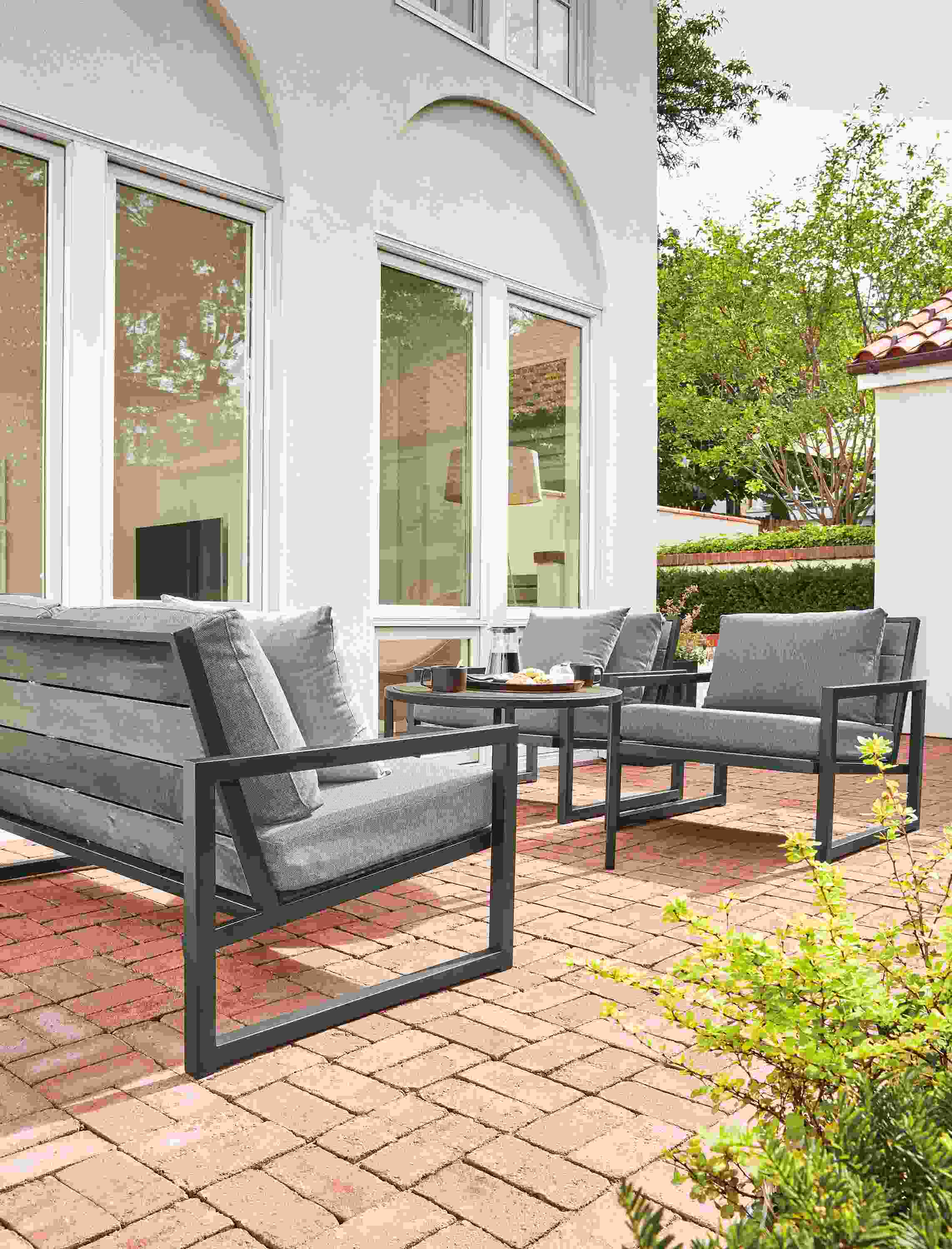 Brick patio with Montego 64-wide bench in aged thermally modified oak with graphite base.