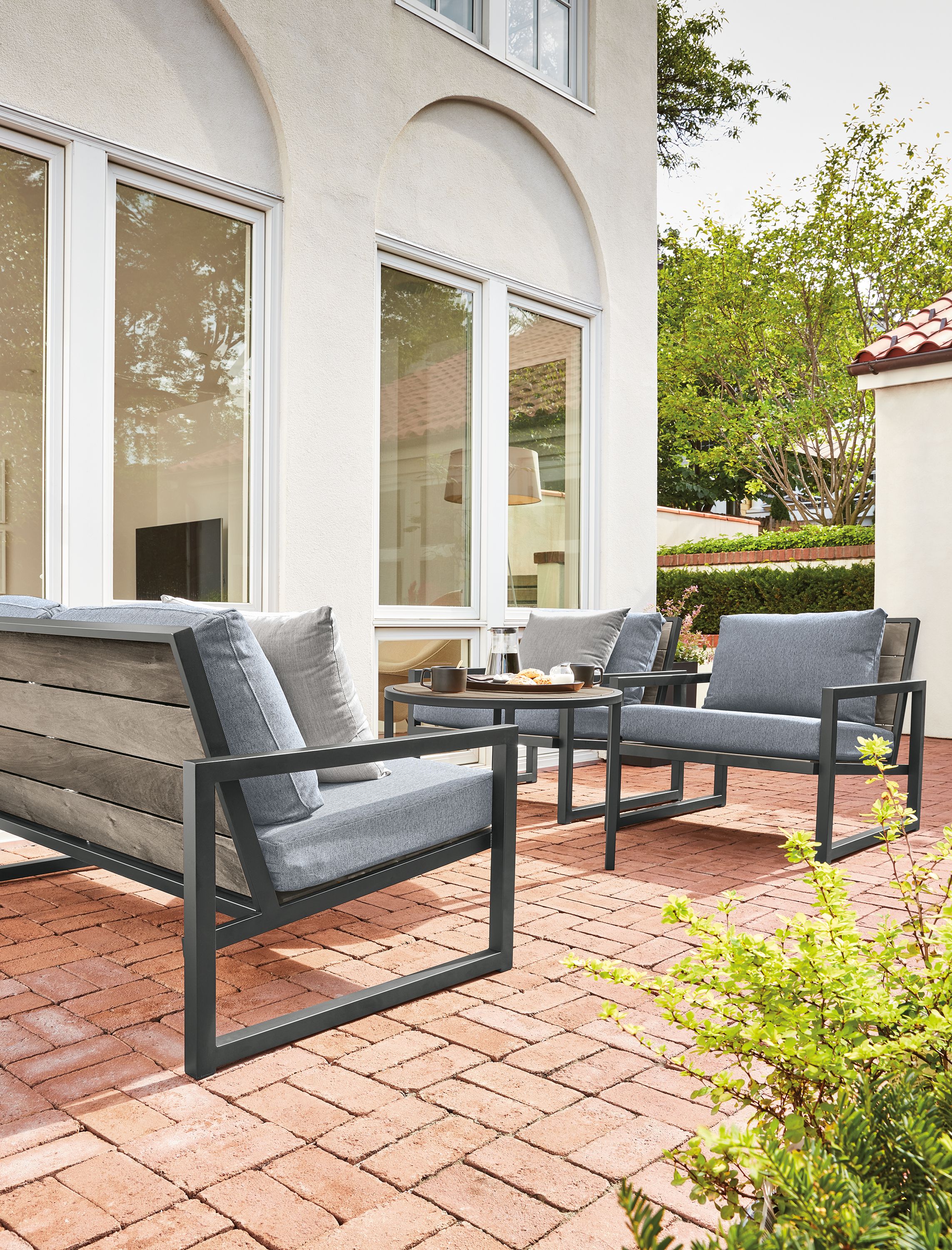 57" sofa in with Mist navy cushions & graphite frame. Over time, the wood will age to the silver-grey color shown.