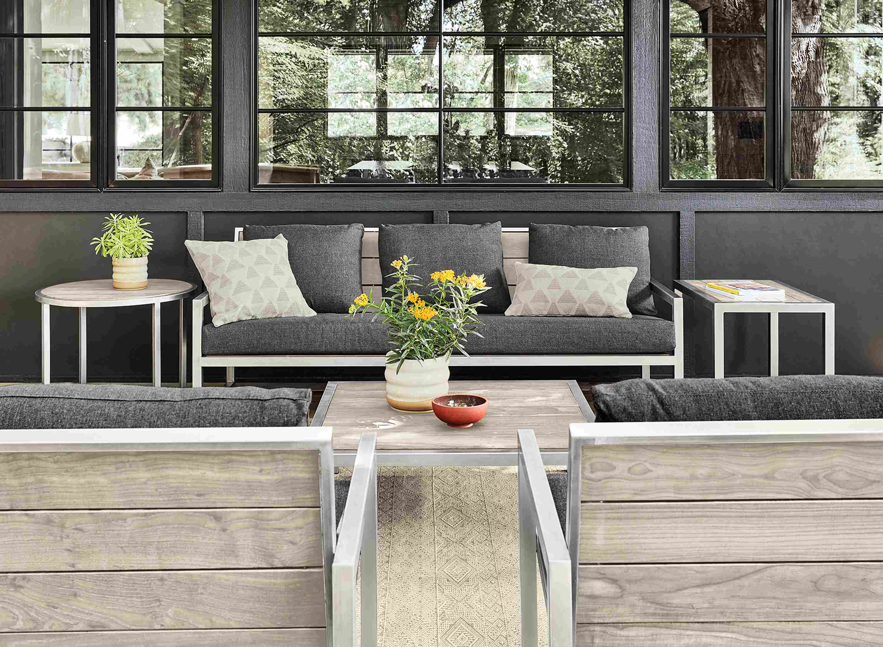 Patio with Montego sofa, lounge chairs and tables in stainless steel and aged thermally modified ash.