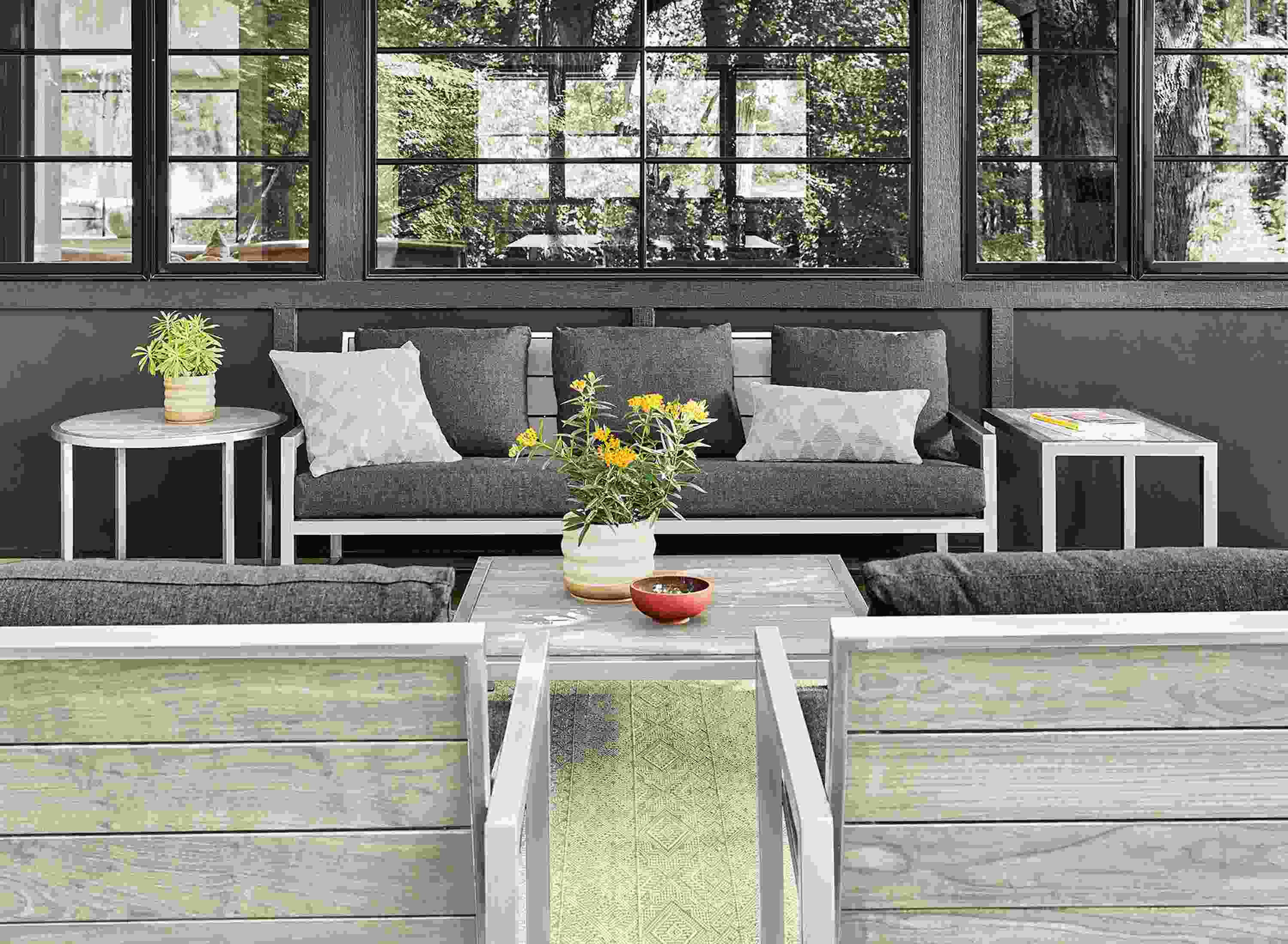 Patio with Montego sofa, lounge chairs and tables in stainless steel and aged thermally modified ash.