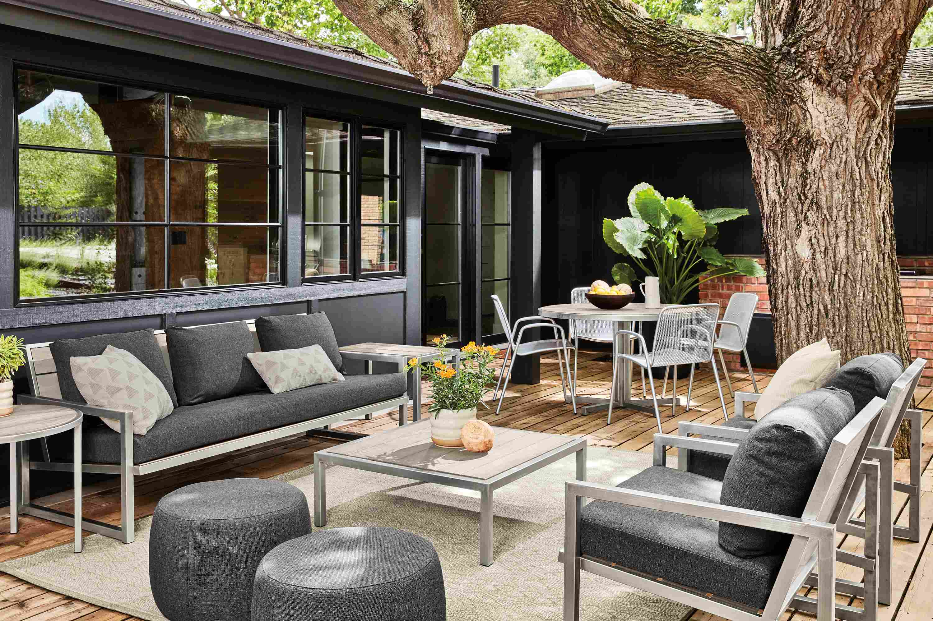 Montego sofa and chairs with Mist Charcoal cushions, and tables in Stainless Steel with aged Thermally modified ash.