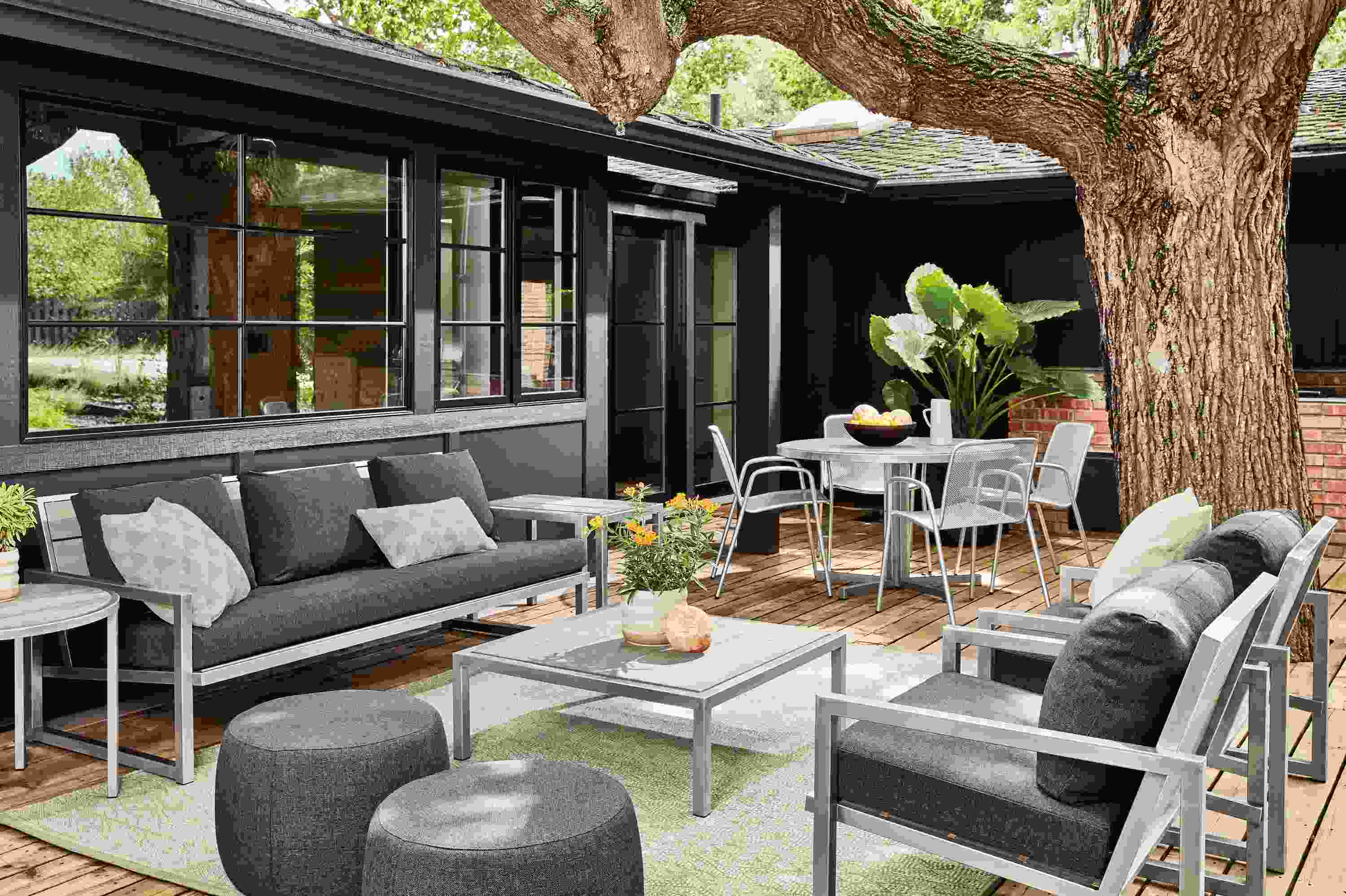 Montego sofa and chairs with Mist Charcoal cushions, and tables in Stainless Steel with aged Thermally modified ash.